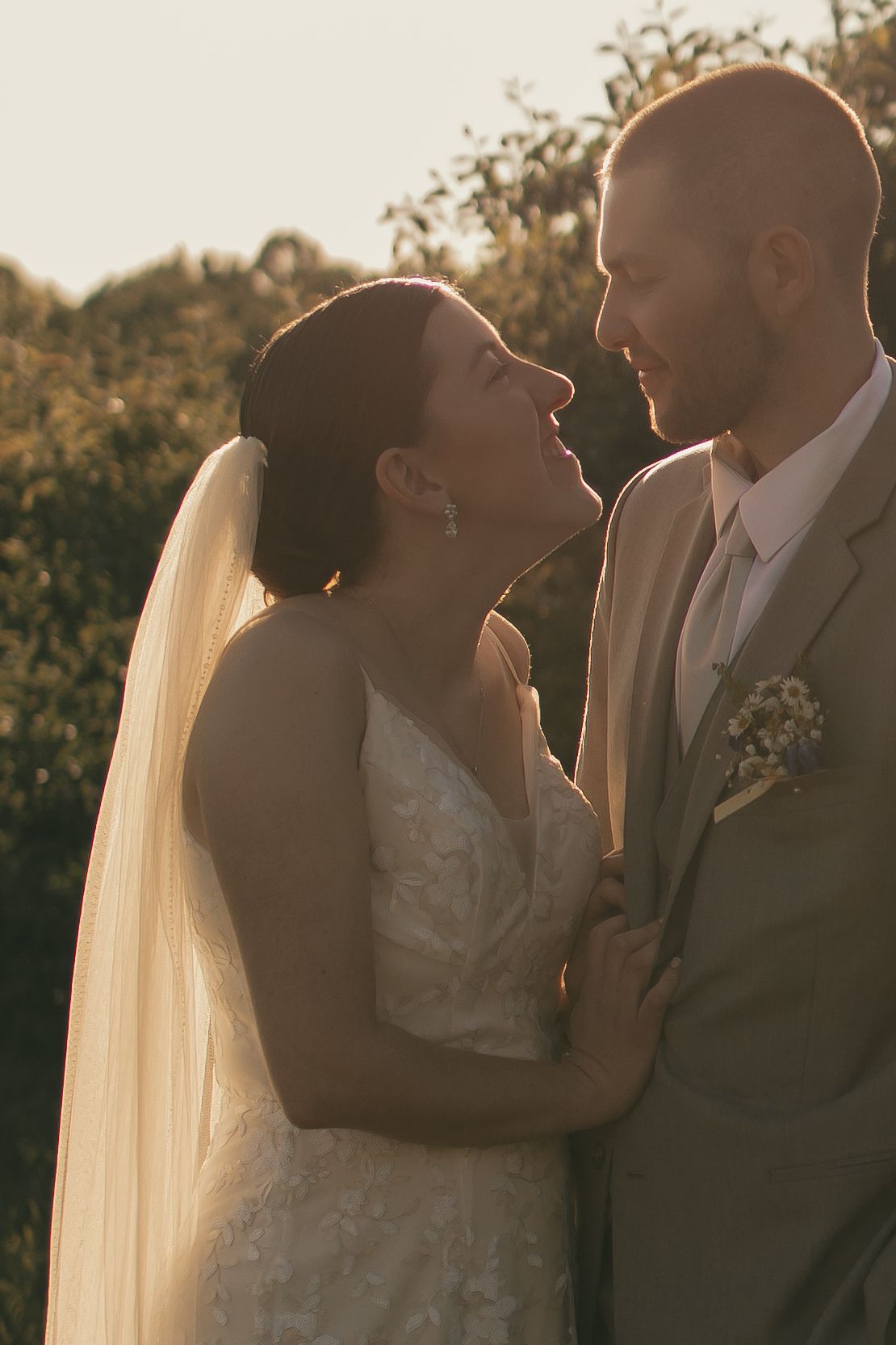 Romantic sunset portrait of newlyweds with bride's veil flowing in golden light in Ashtabula Ohio by Gypsy Lens Photography. Moody wedding