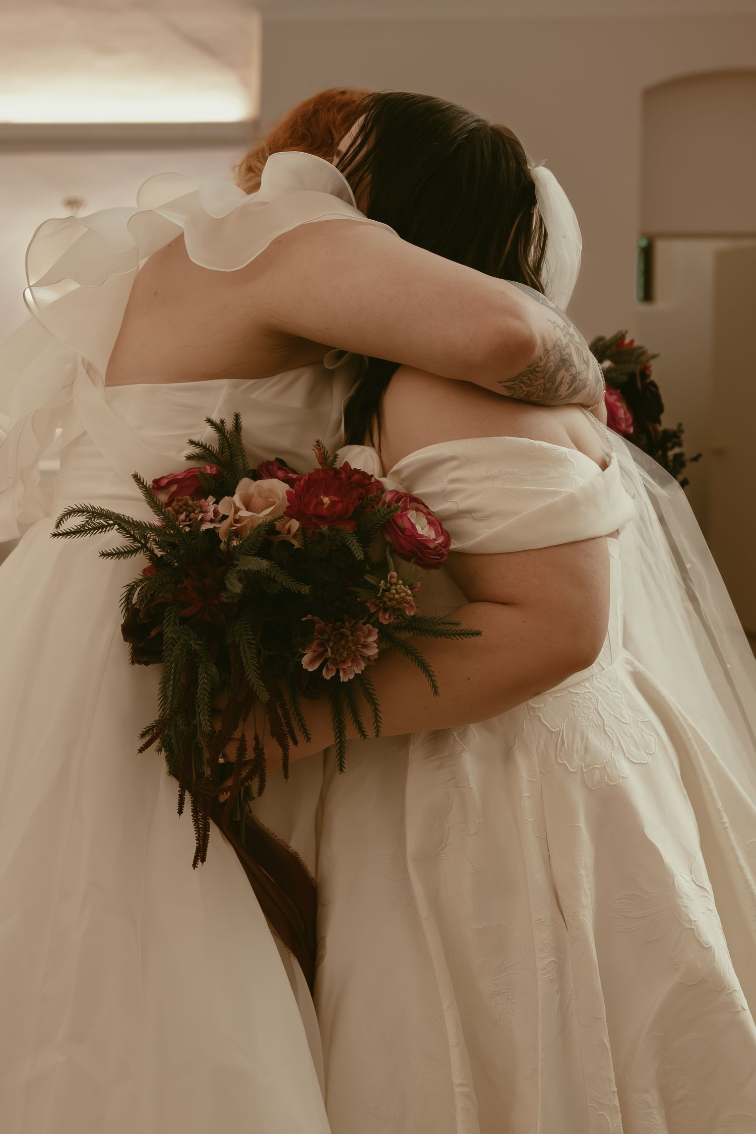 Two brides hugging at first look in Cleveland Ohio by Gypsy Lens Photography. Moody, filmy, vintage, documentary wedding photography.