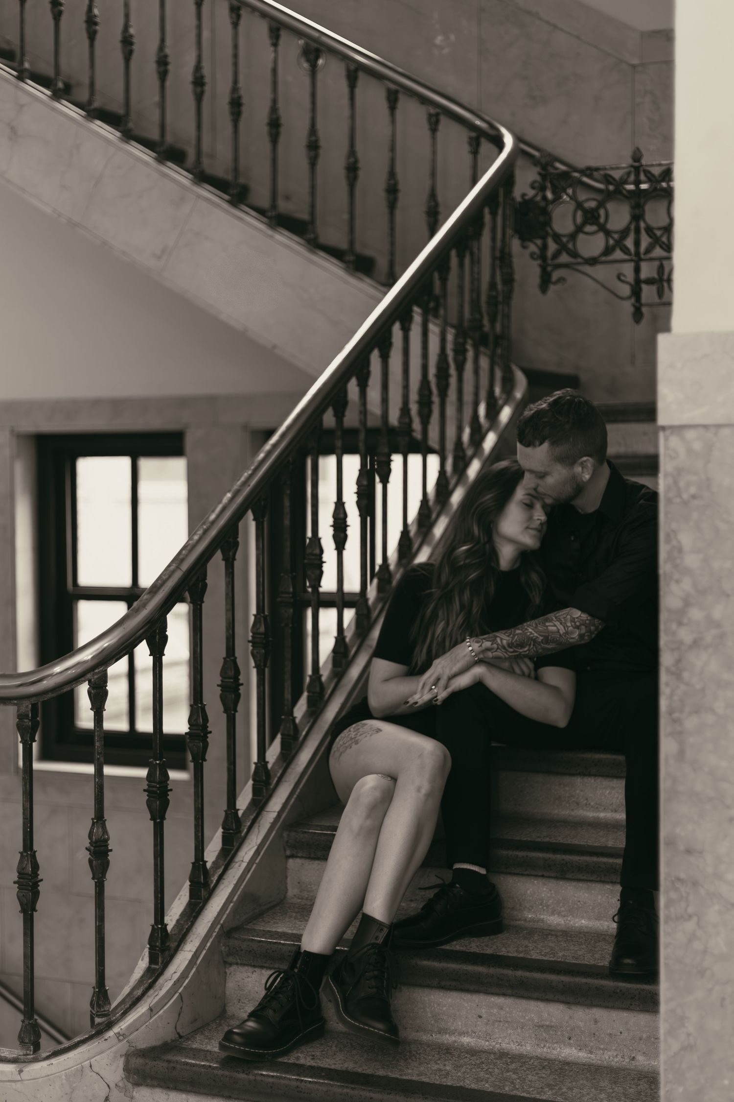 Couple sitting on vintage staircase at library in Cleveland Ohio by Gypsy Lens Photography. Moody, filmy, vintage, documentary wedding photo