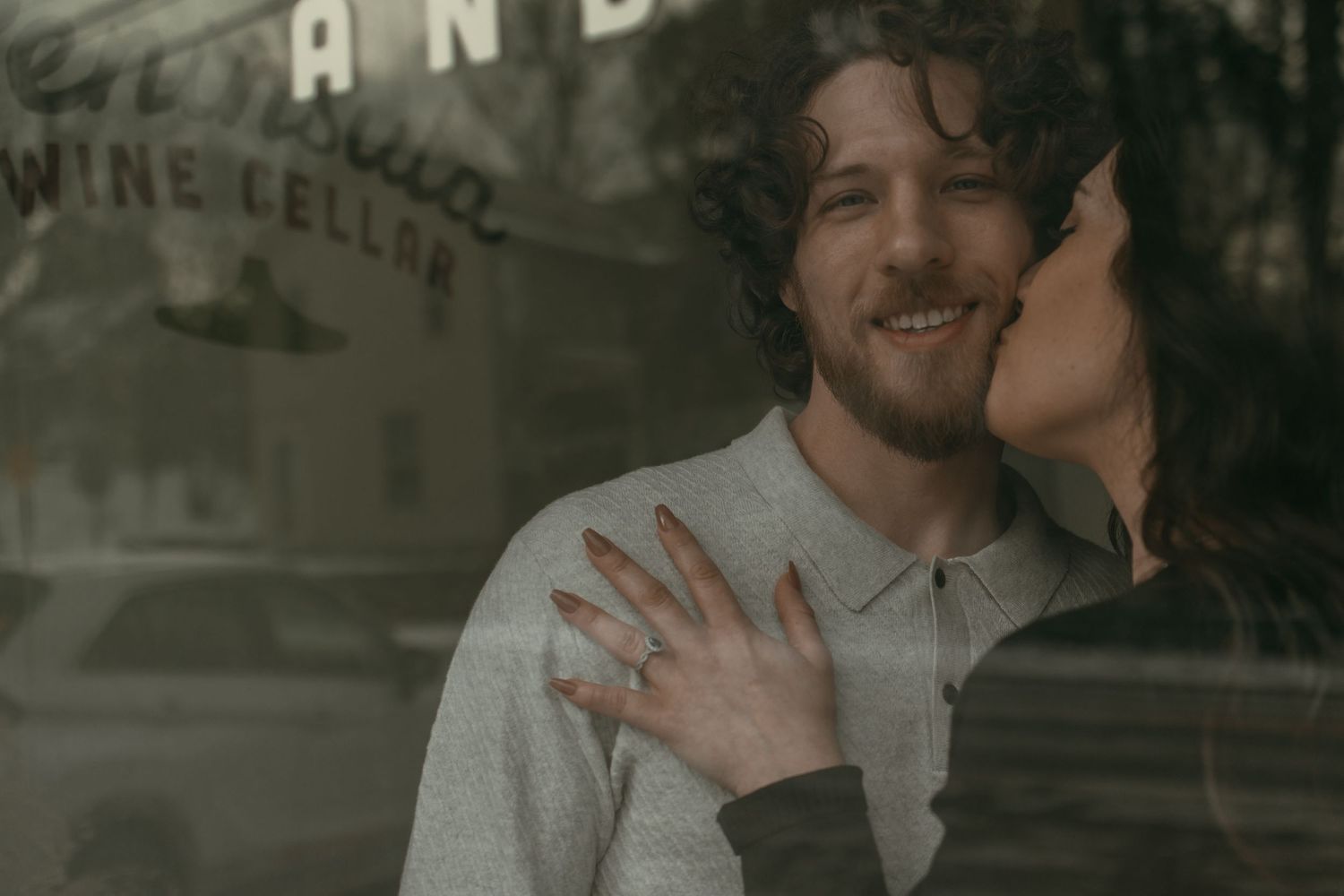 Cinematic window photo of engaged couple in Cleveland Ohio by Gypsy Lens Photography. Moody, vintage, documentary wedding photographer.
