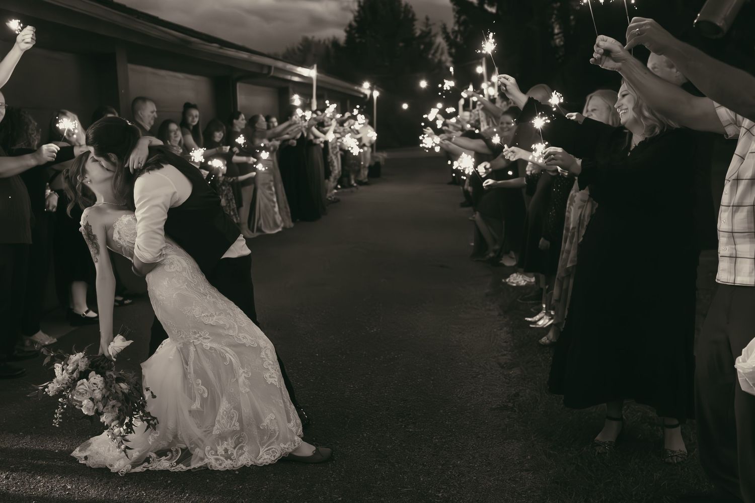 Couple kissing at sparkler exit in Hermitage Pennsylvania by Gypsy Lens Photography. Moody, vintage, documentary wedding photo.