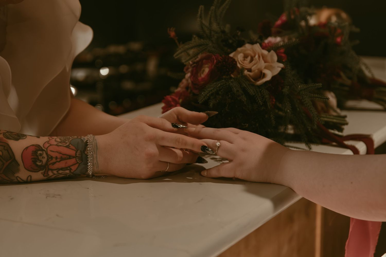 Two brides holding hands at bar in Cleveland Ohio by Gypsy Lens Photography. Moody, filmy, vintage, documentary wedding photography.