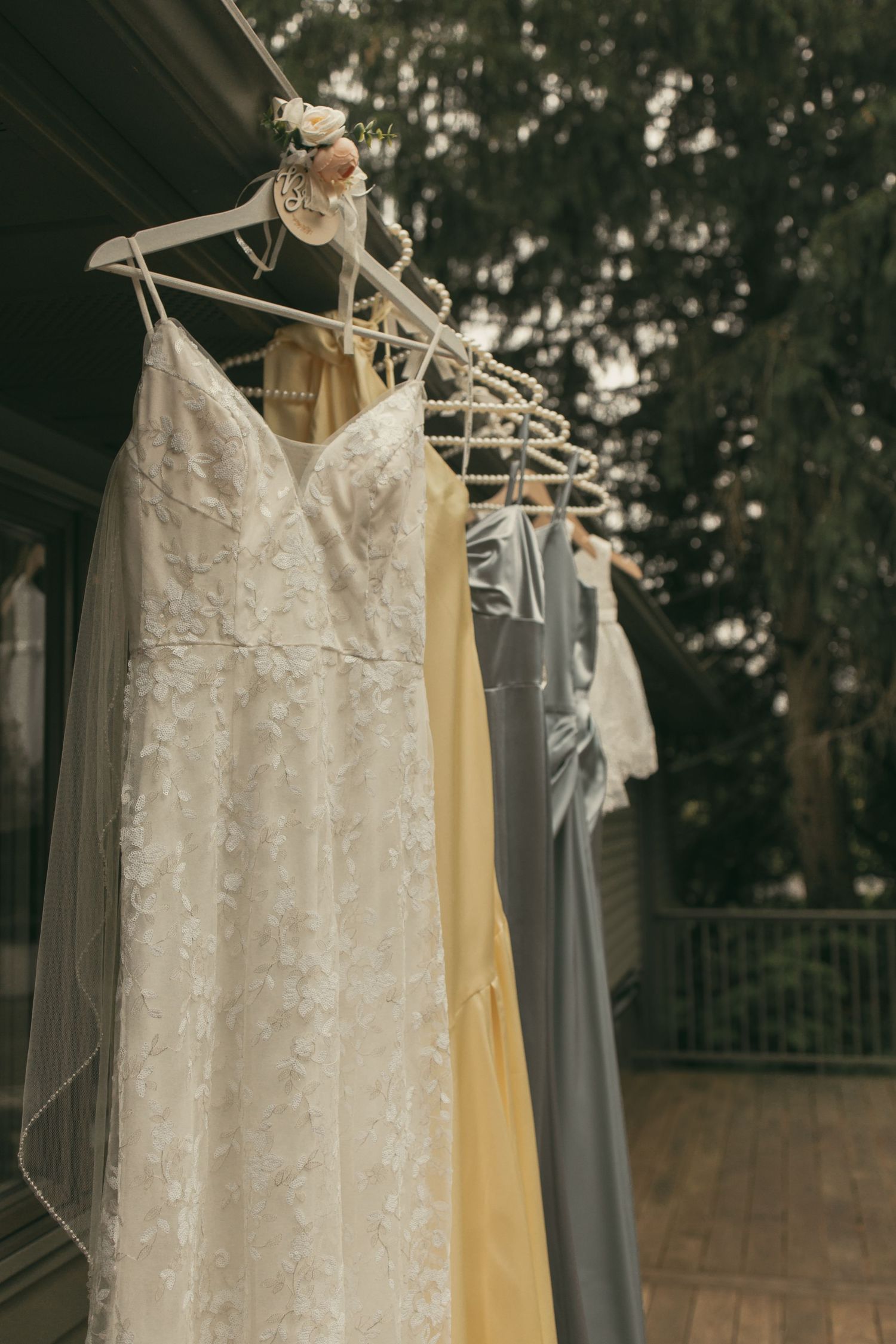 Wedding dress and bridesmaid dresses hanging in Ashtabula Ohio by Gypsy Lens Photography. Moody, vintage, documentary wedding photographer.
