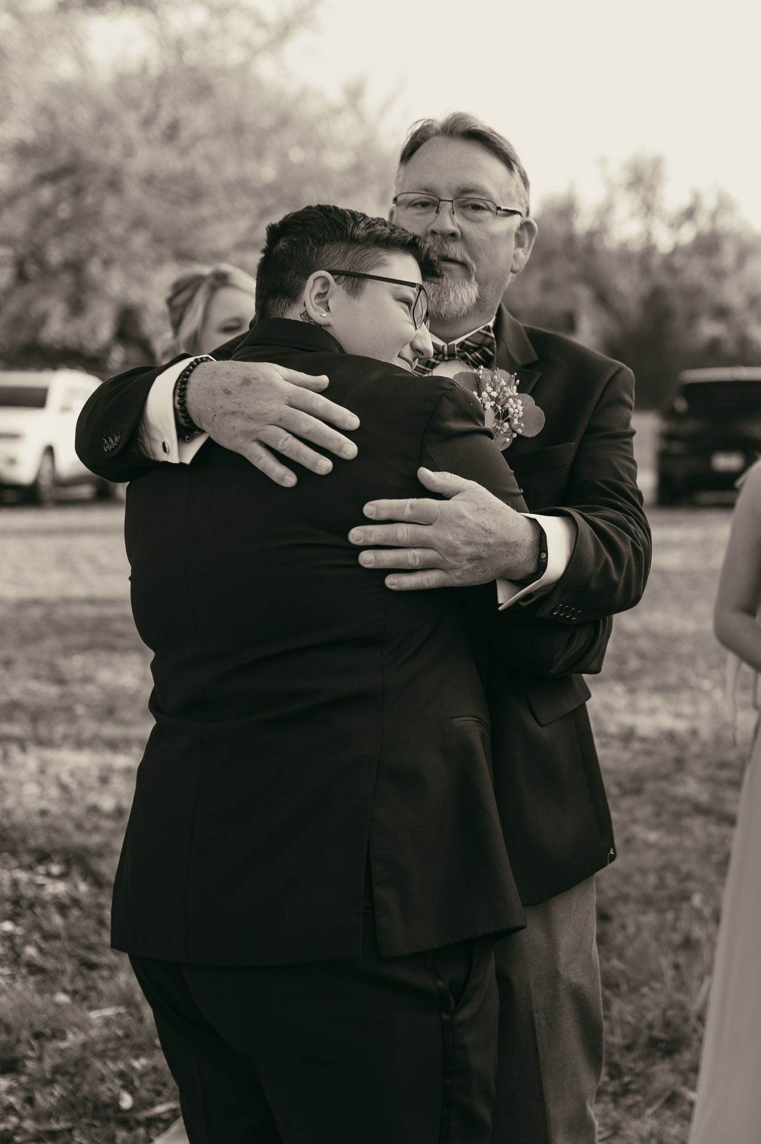 Bride hugging father in law on wedding day in Cleveland Ohio by Gypsy Lens Photography. Moody, vintage, documentary wedding photography.