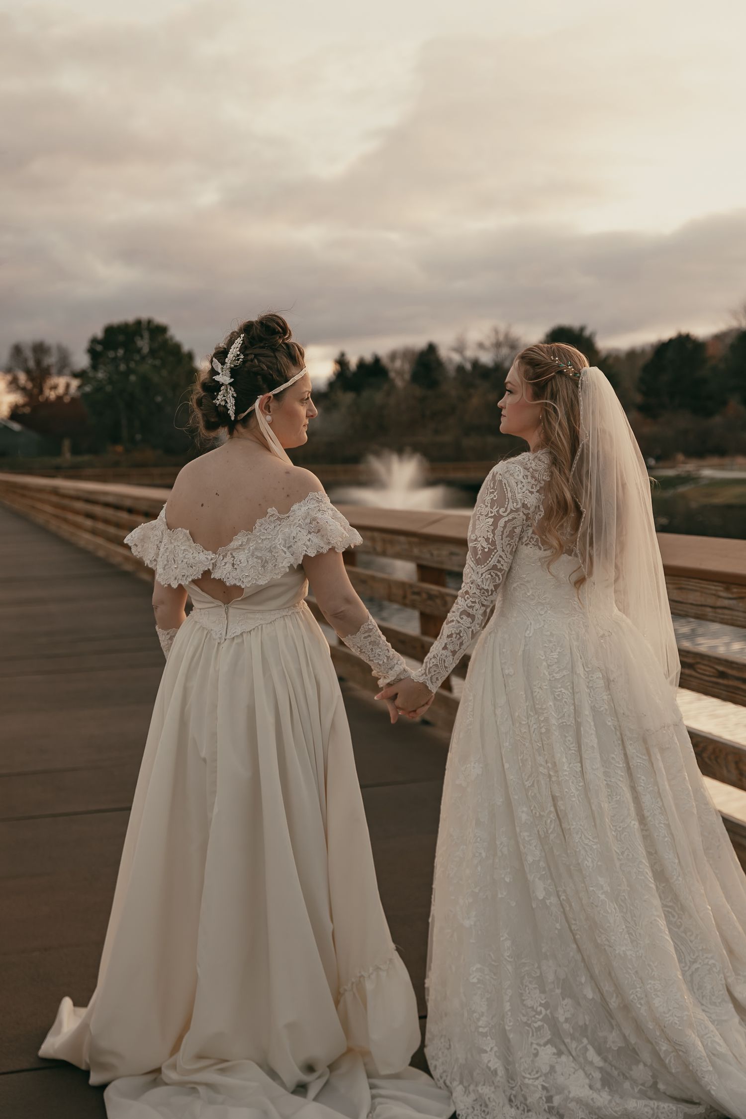 Two brides share an intimate moment in their wedding dresses  in Lake County Ohio by Gypsy Lens Photography. Moody, vintage, documentary.