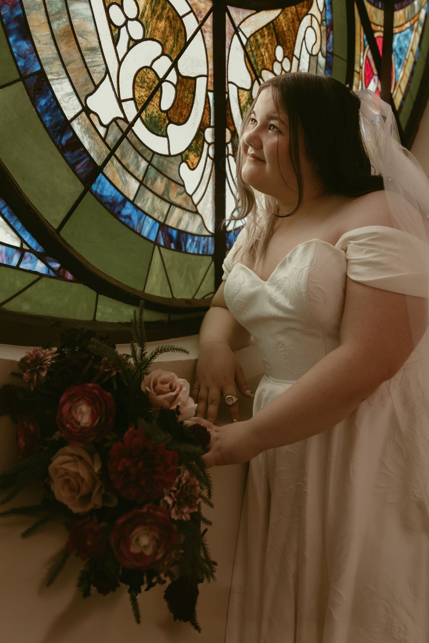 Bride in front of stained glass window in Cleveland Ohio by Gypsy Lens Photography. Moody, filmy, vintage, documentary wedding photography.