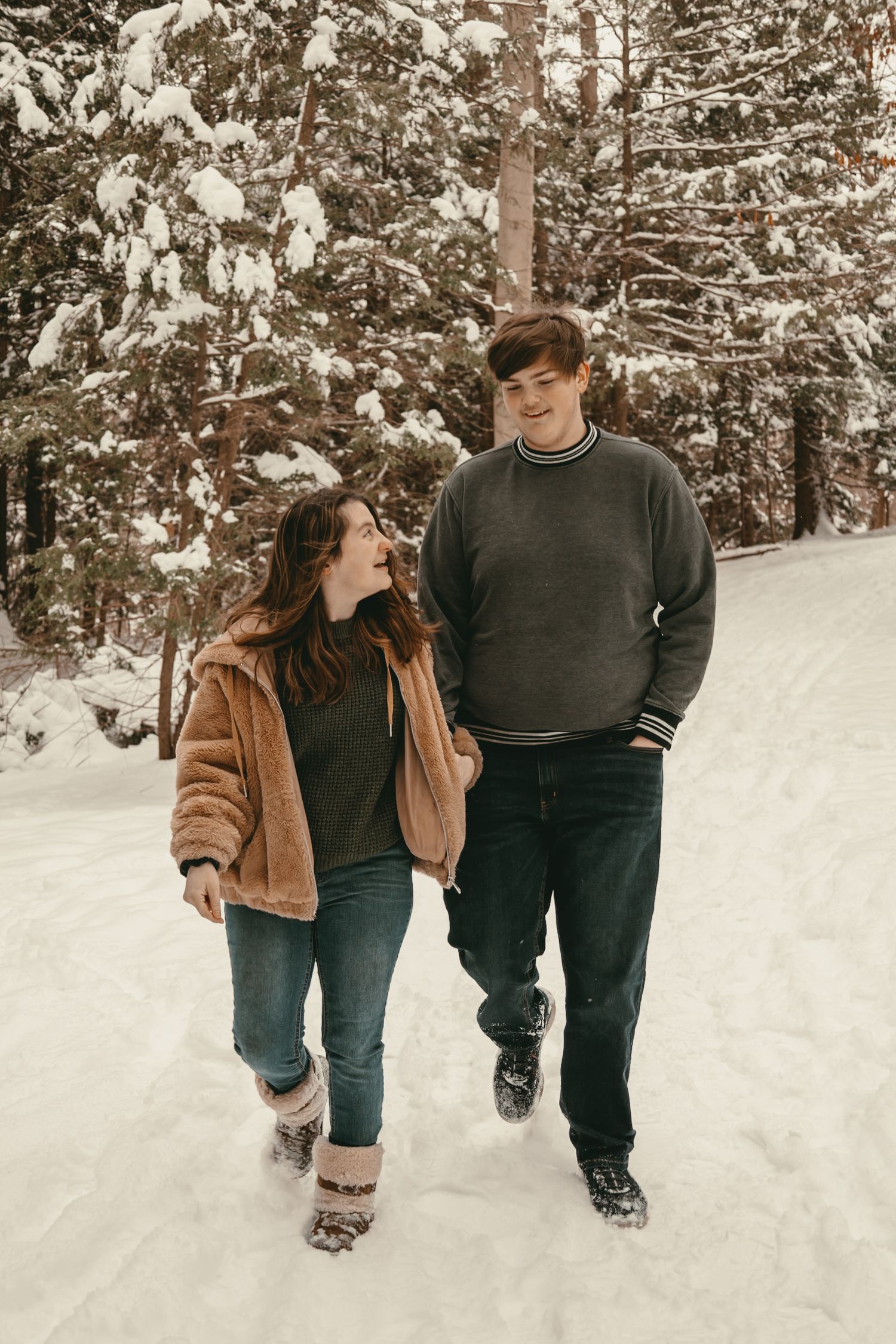 Engaged couple walking at park in winter in Lake County Ohio by Gypsy Lens Photography. Moody, vintage, documentary wedding photographer.