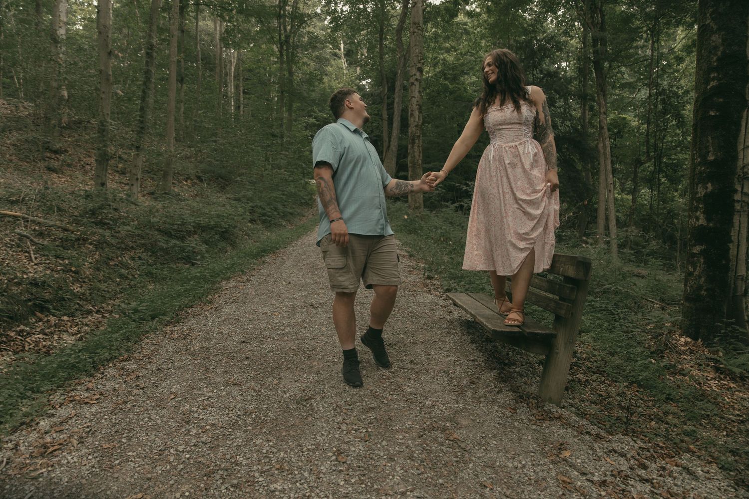 Couple walking through forest in Lake County Ohio by Gypsy Lens Photography. Moody, filmy, vintage, documentary wedding photography