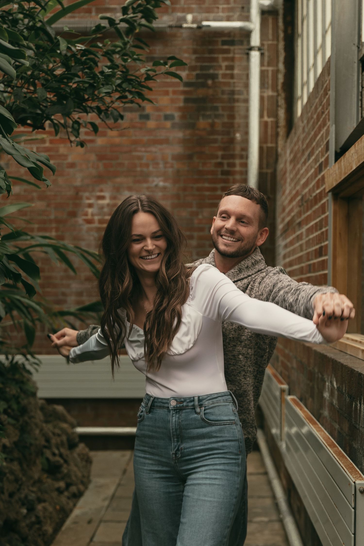 Playful couple having fun at greenhouse in Cleveland Ohio by Gypsy Lens Photography. Moody, filmy, vintage, documentary wedding photography