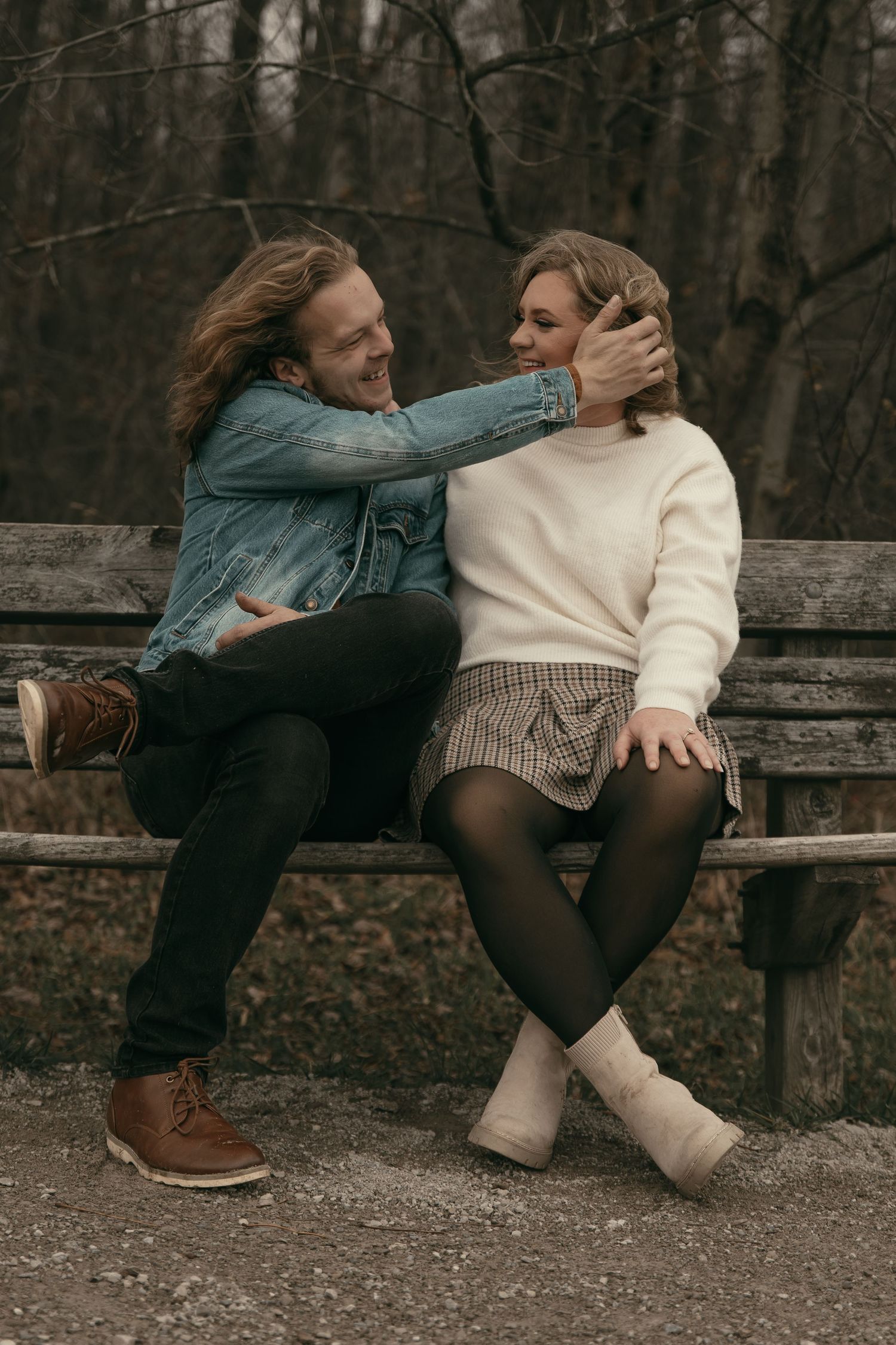 Engaged couple sitting on bench in Lake County Ohio by Gypsy Lens Photography. Moody, filmy, vintage, documentary wedding photography
