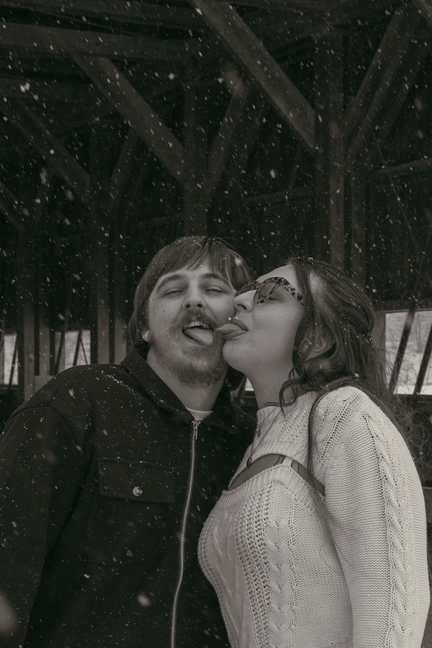 Couple catching snowflakes in Ashtabula Ohio by Gypsy Lens Photography. Moody, vintage, documentary wedding photography.
