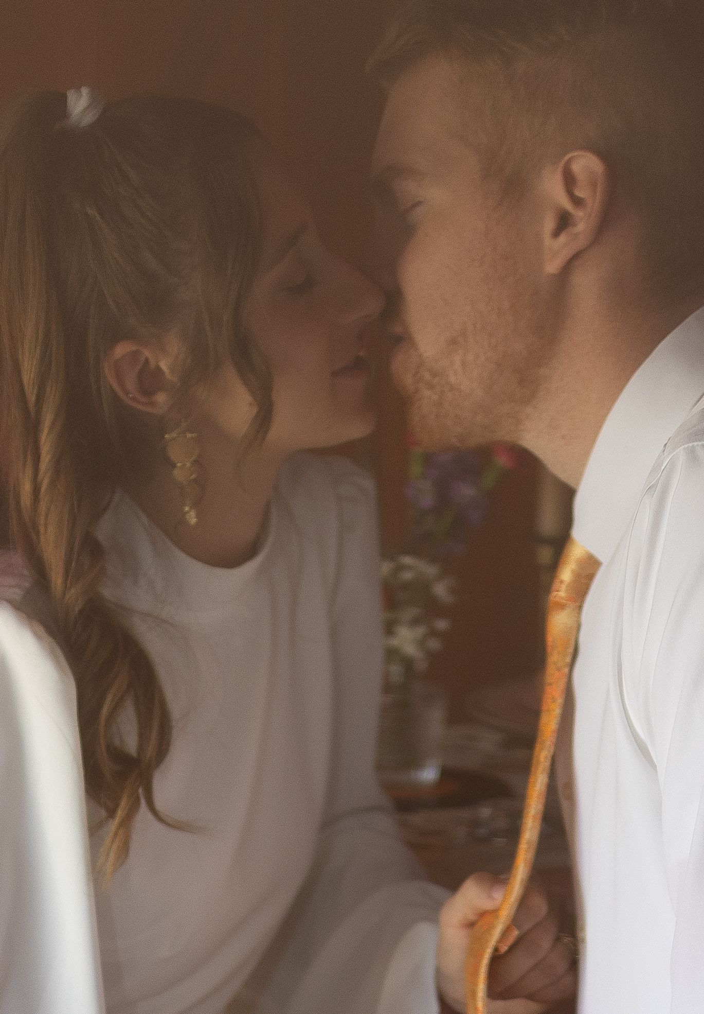 Couple kissing before cutting cake at elopement in Akron Ohio by Gypsy Lens Photography. Moody, vintage, nostalgic documentary wedding.