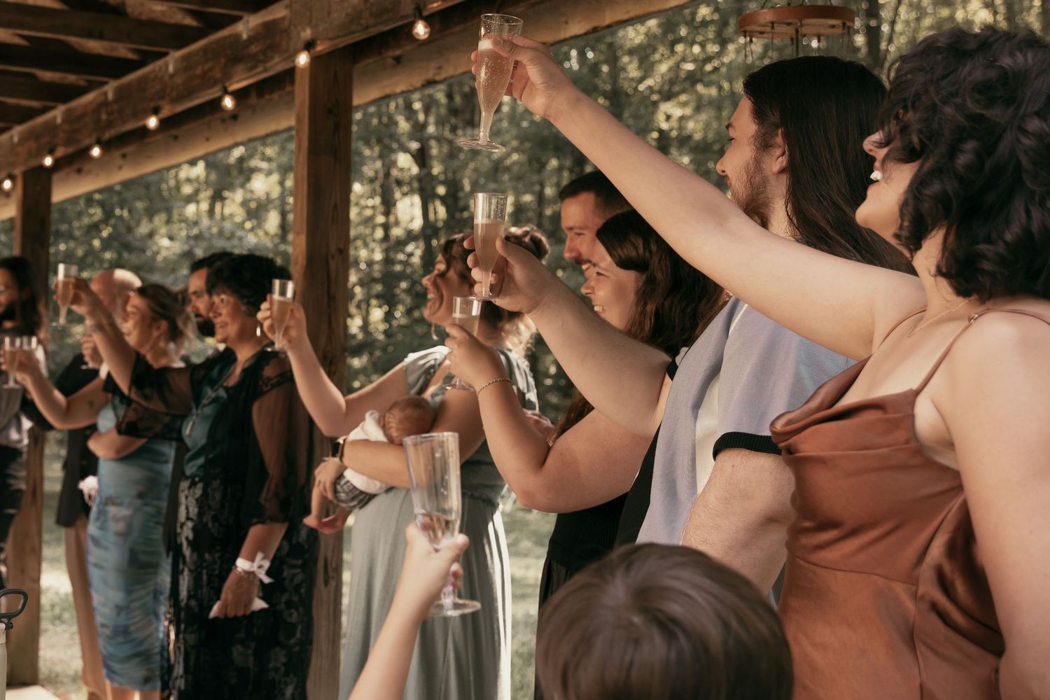 Wedding guests raising their glasses in a toast in Tallmadge Ohio by Gypsy Lens Photography. Moody, vintage, nostalgic documentary wedding