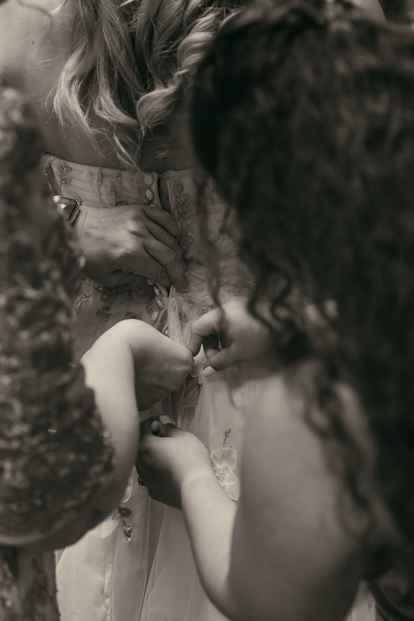 Bride having dress zipped up in Akron Ohio by Gypsy Lens Photography. Moody, filmy, vintage, documentary wedding photography.