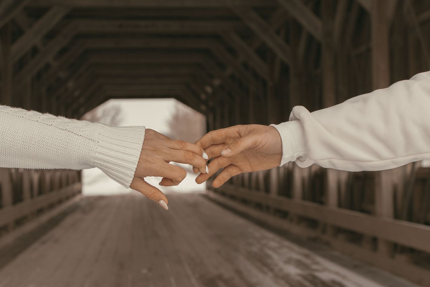Close up of couples hands at covered bridge in Ashtabula Ohio by Gypsy Lens Photography. Moody, vintage, documentary wedding photographer.
