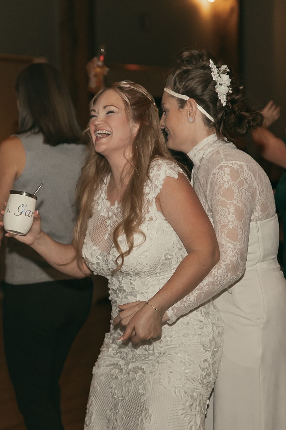 Two brides at reception at wedding in Lake County Ohio by Gypsy Lens Photography. Moody, vintage, documentary wedding photography.