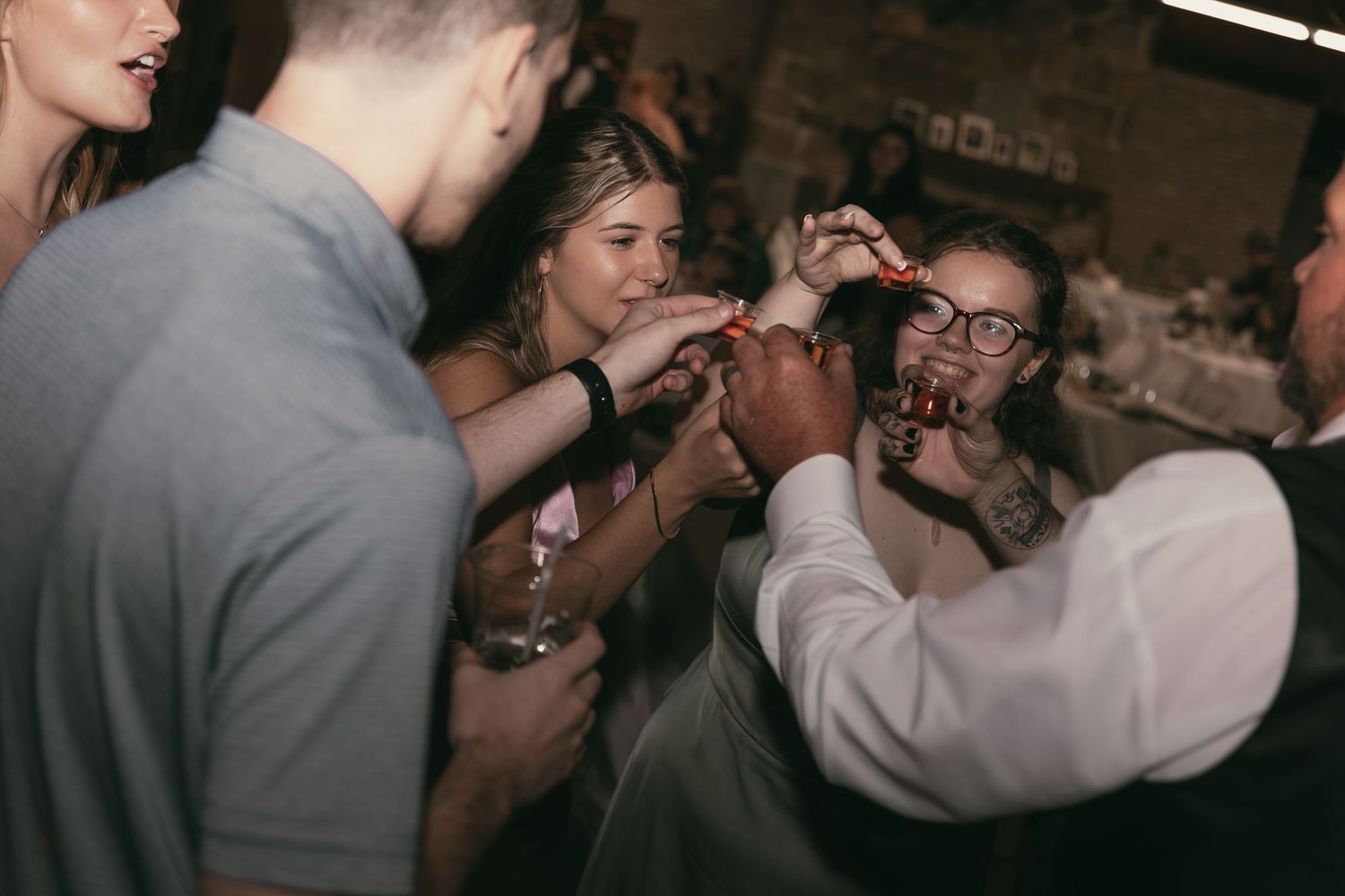 Wedding guests toasting in Hermitage Pennsylvania by Gypsy Lens Photography. Moody, vintage, documentary wedding photo.