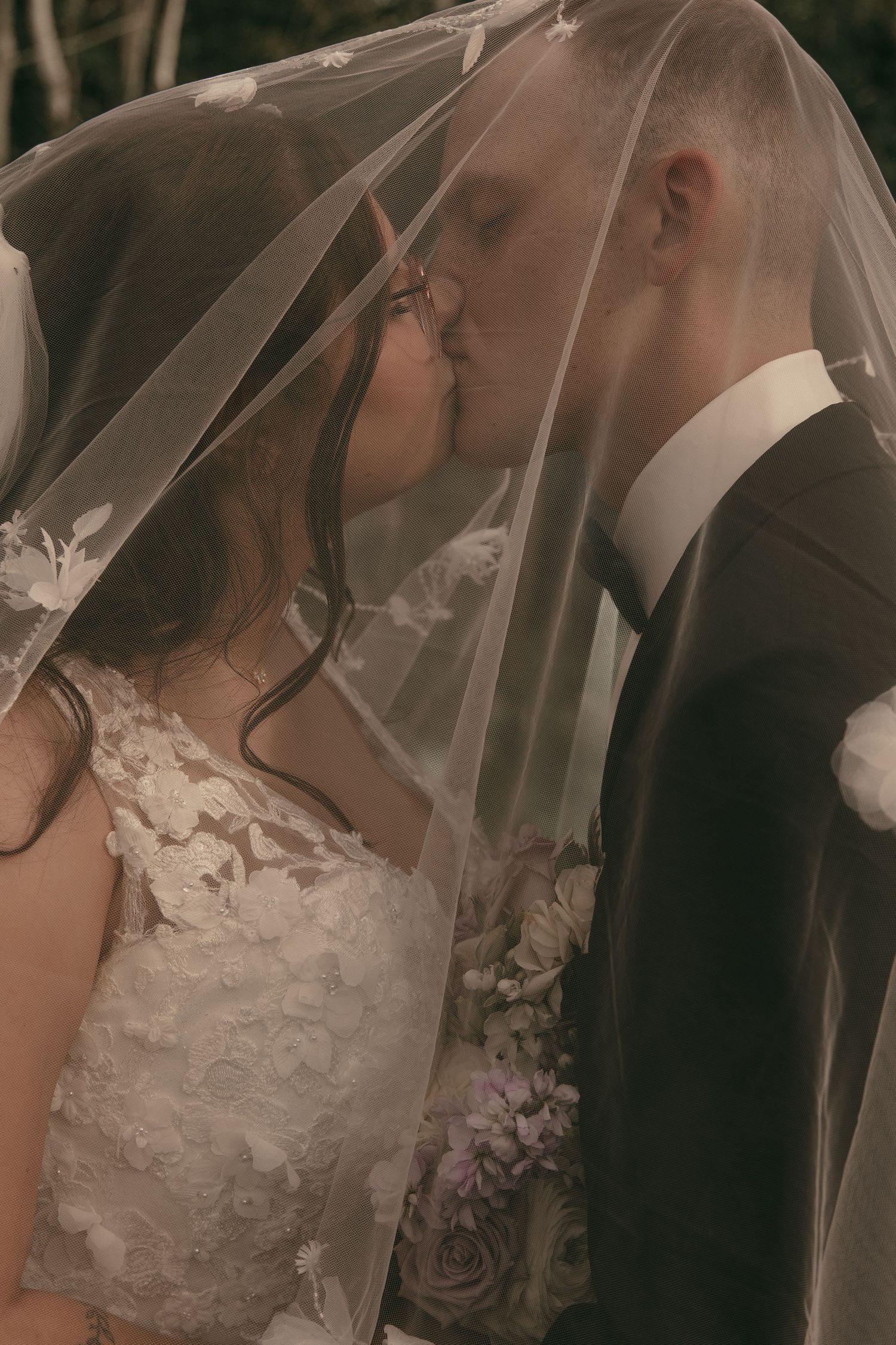 Bride and groom kissing under veil in Cleveland Ohio by Gypsy Lens Photography. Moody, vintage, documentary wedding photographer.