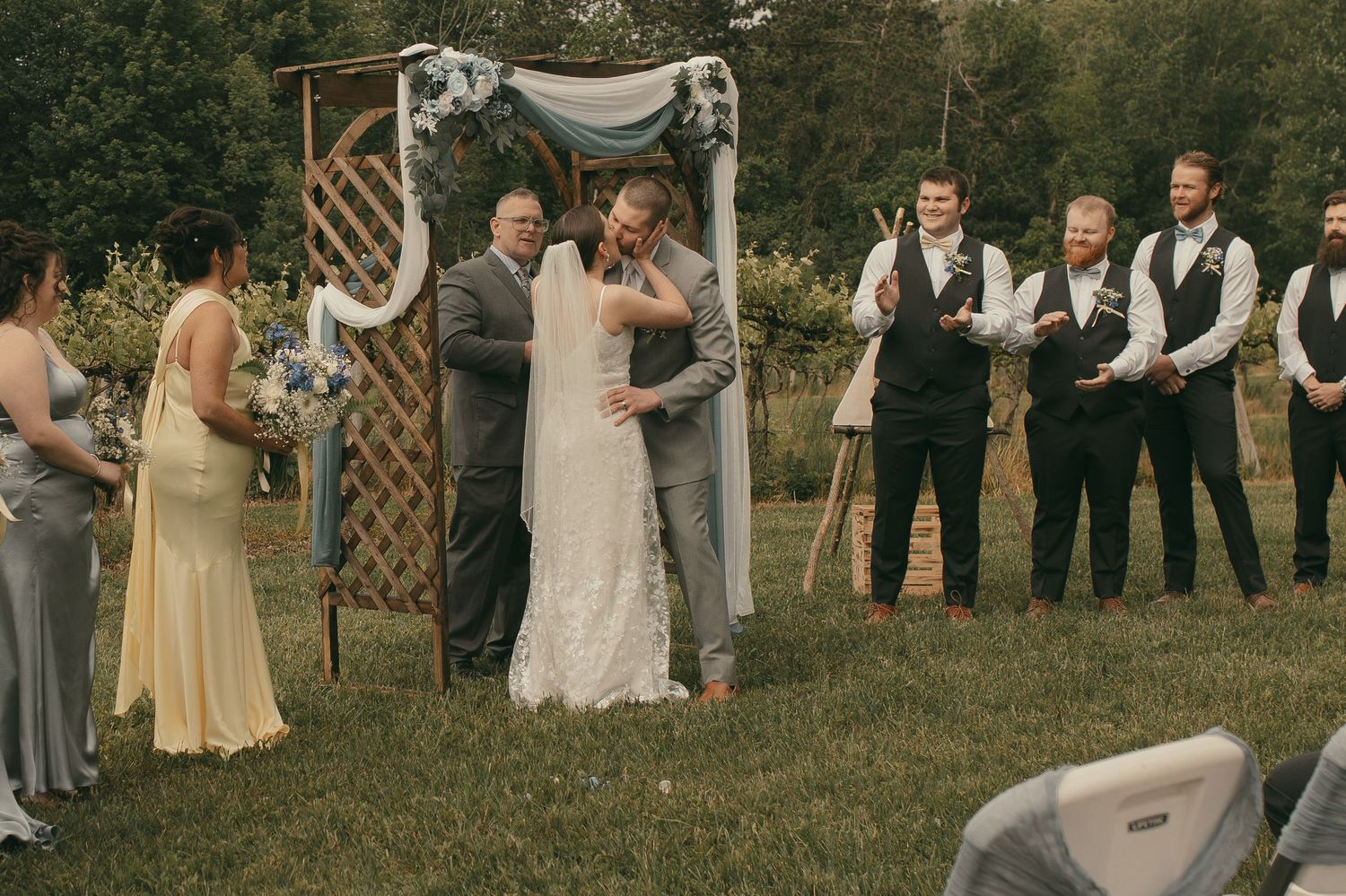 Bride and groom share first kiss at the alter in Ashtabula Ohio by Gypsy Lens Photography. Moody, vintage, documentary wedding photographer.