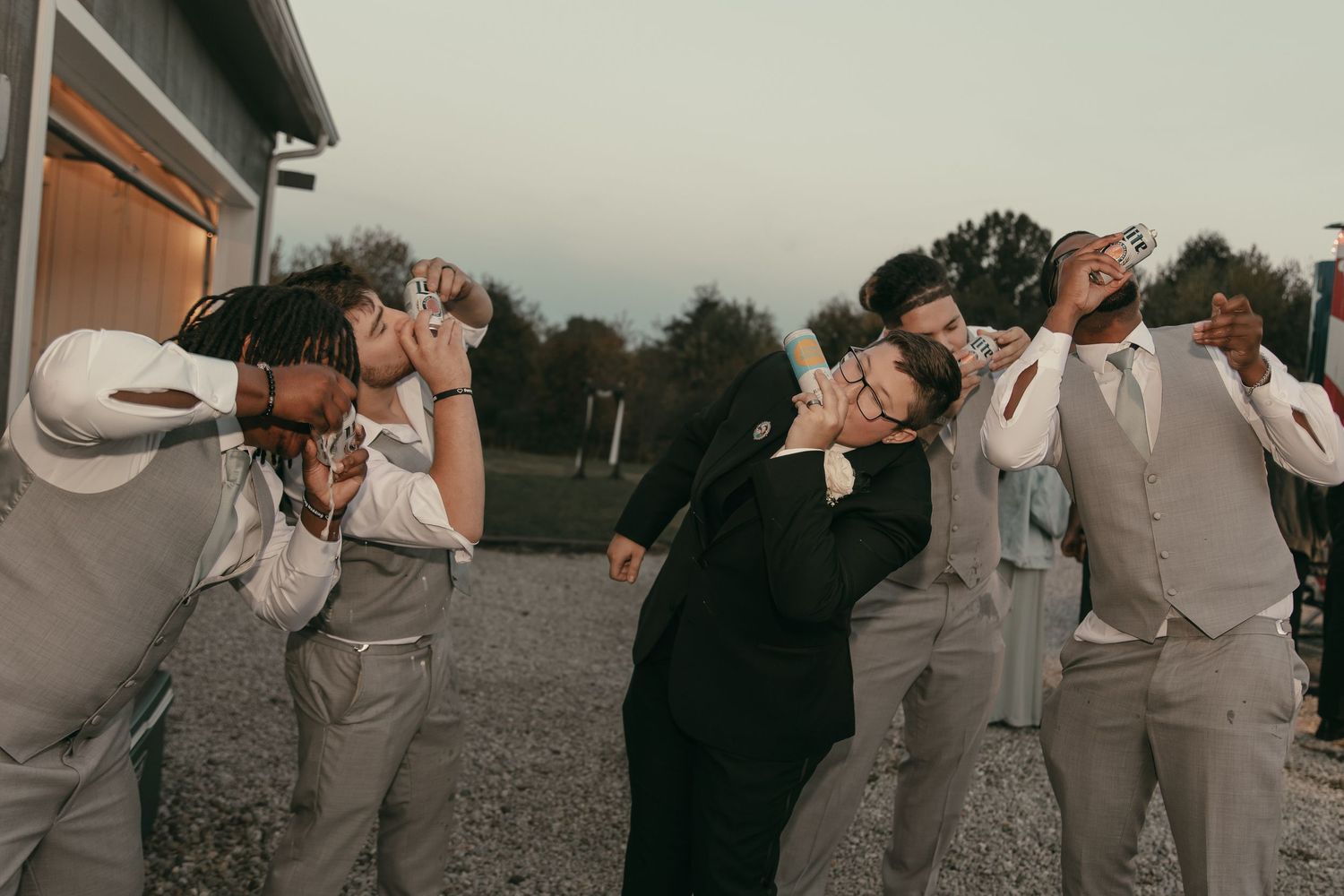 Wedding party shotgunning beer in Cleveland Ohio by Gypsy Lens Photography. Moody, vintage, documentary wedding photography.
