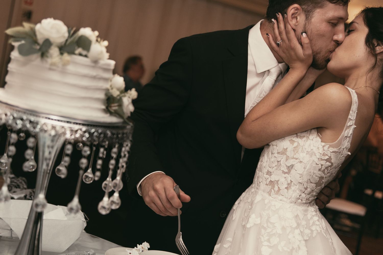 Newlyweds kissing before cake cutting in Tallmadge Ohio by Gypsy Lens Photography. Moody, vintage, nostalgic, documentary wedding.