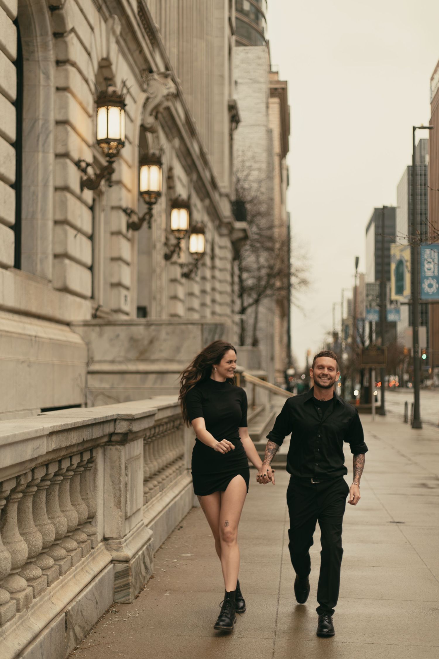 Couple runs playfully in big city of Cleveland Ohio by Gypsy Lens Photography. Moody, nostalgic, vintage, documentary wedding photography