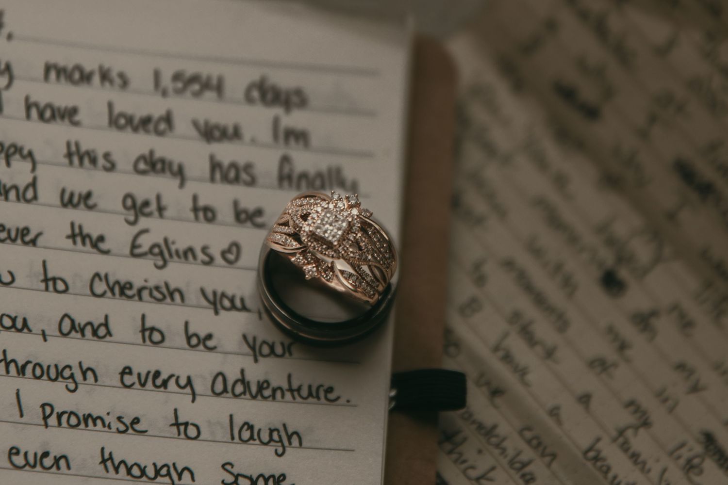 Close-up of handwritten wedding vows on paper with a ring in Wooster Ohio by Gypsy Lens Photography. Moody, vintage, nostalgic, documentary.