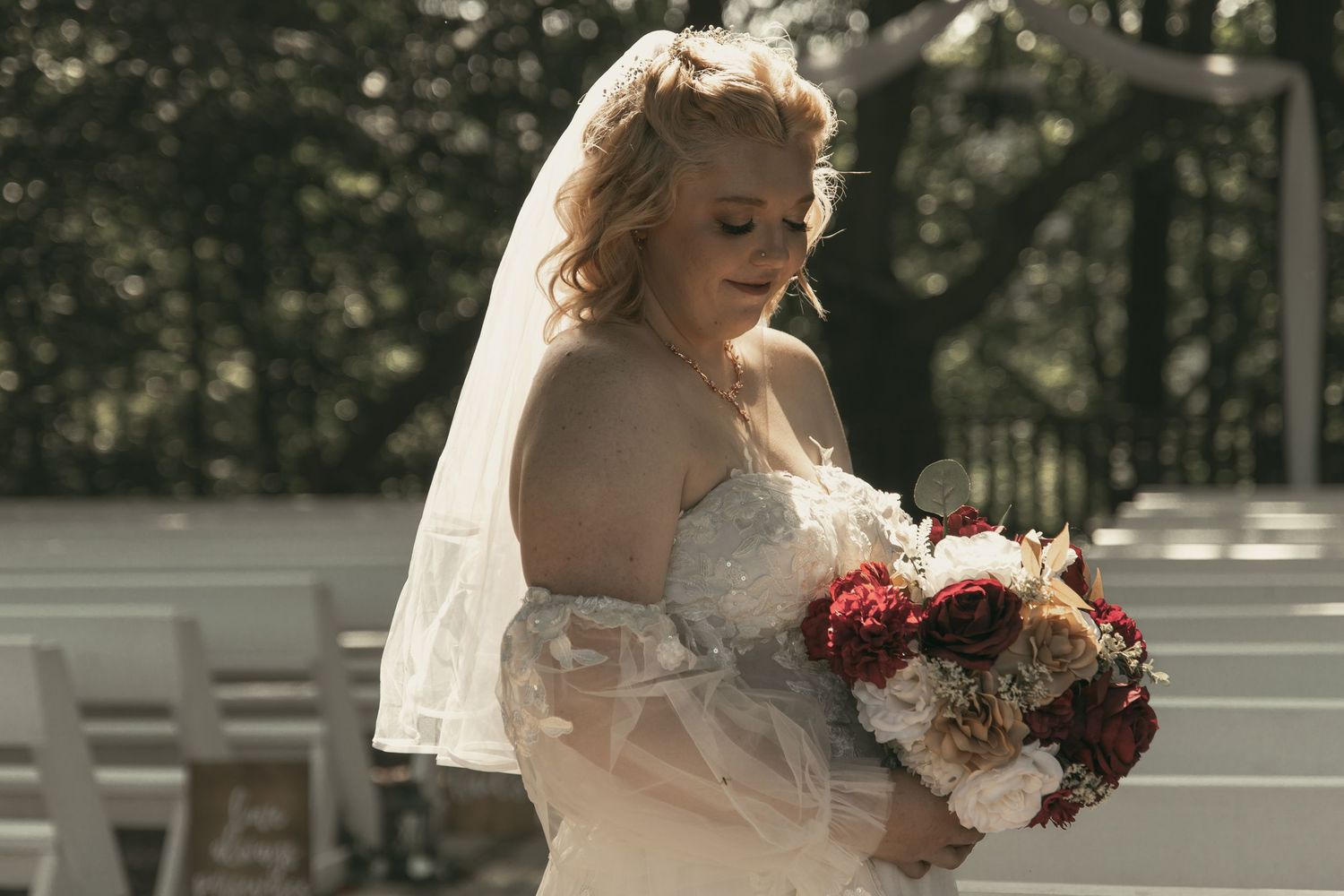 Bride in white lace gown holding a bouquet outdoors in Wooster Ohio by Gypsy Lens Photography. Moody, vintage, documentary wedding photo.