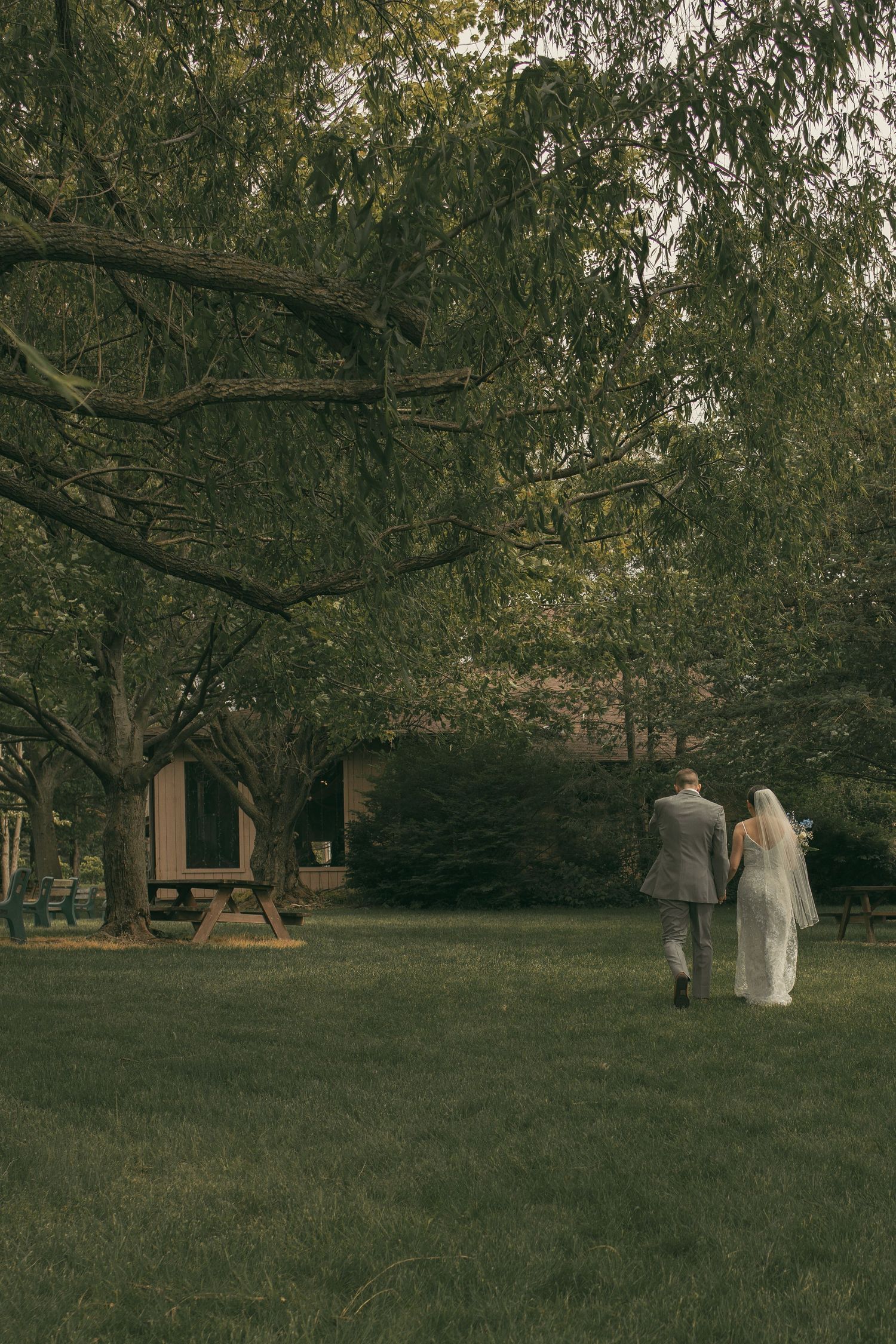 Bride and groom walking after ceremony in Ashtabula Ohio by Gypsy Lens Photography. Moody, vintage, nostalgic, documentary wedding photo.
