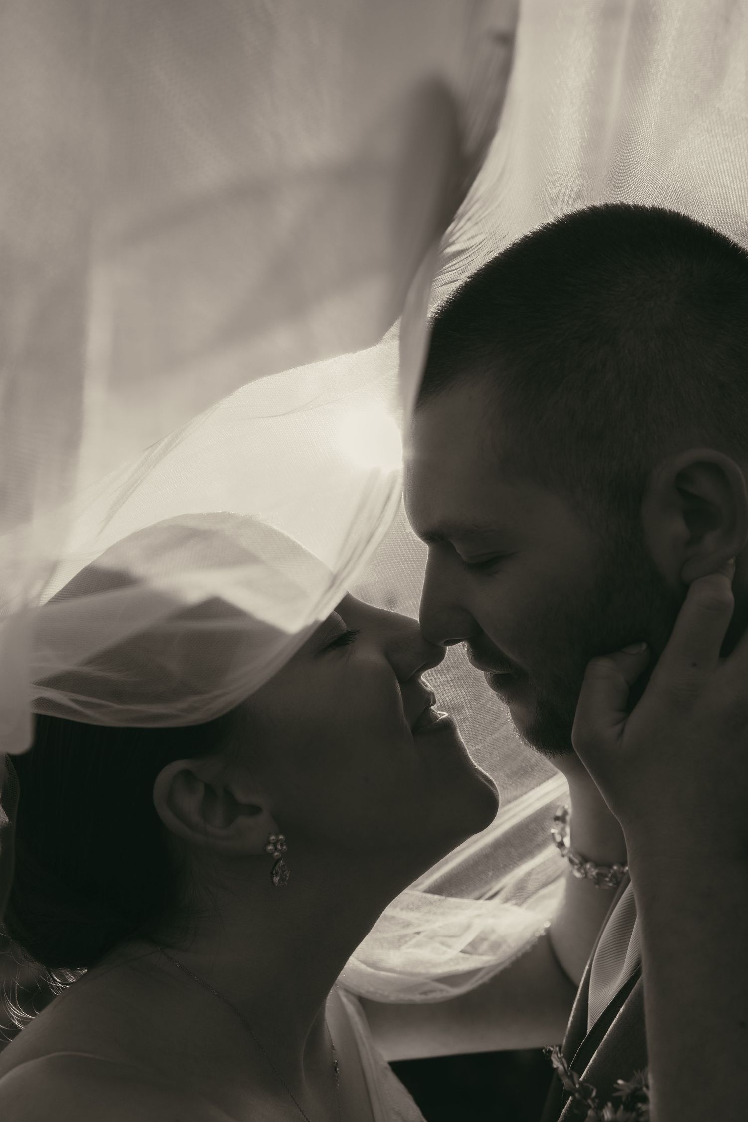 Artistic black and white close-up of couple under veil in Ashtabula Ohio by Gypsy Lens Photography. Moody, vintage, documentary wedding.