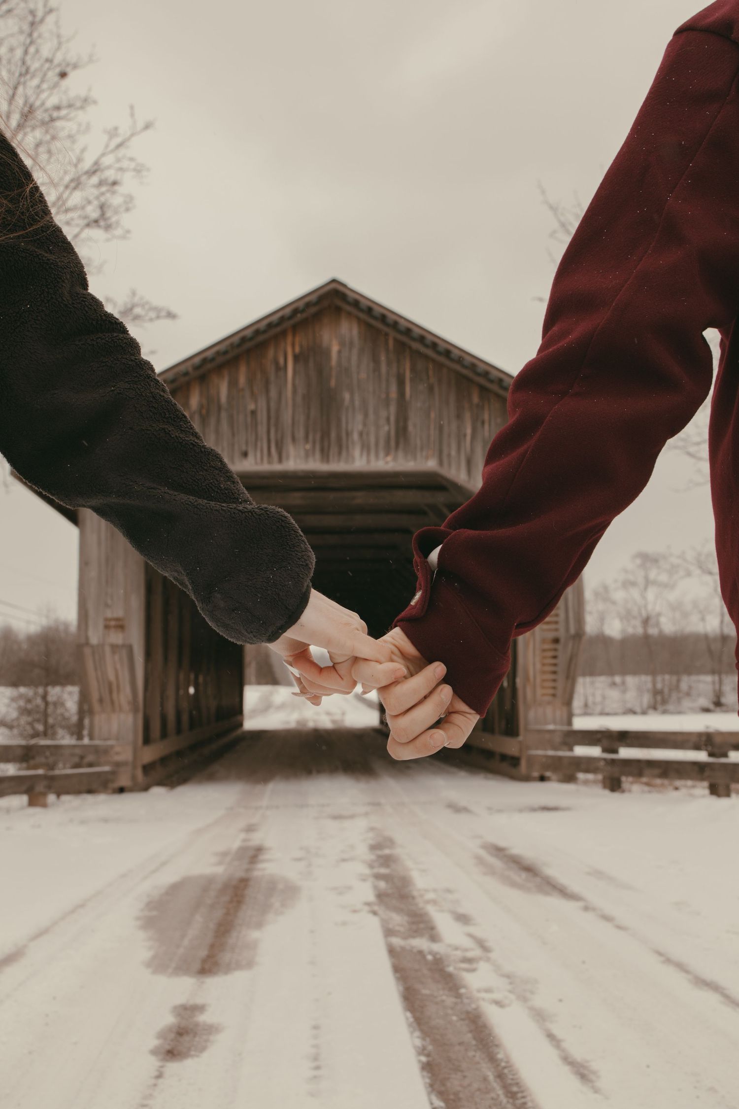 Close up of couples hands at covered bridge in Ashtabula Ohio by Gypsy Lens Photography. Moody, vintage, documentary wedding photographer.