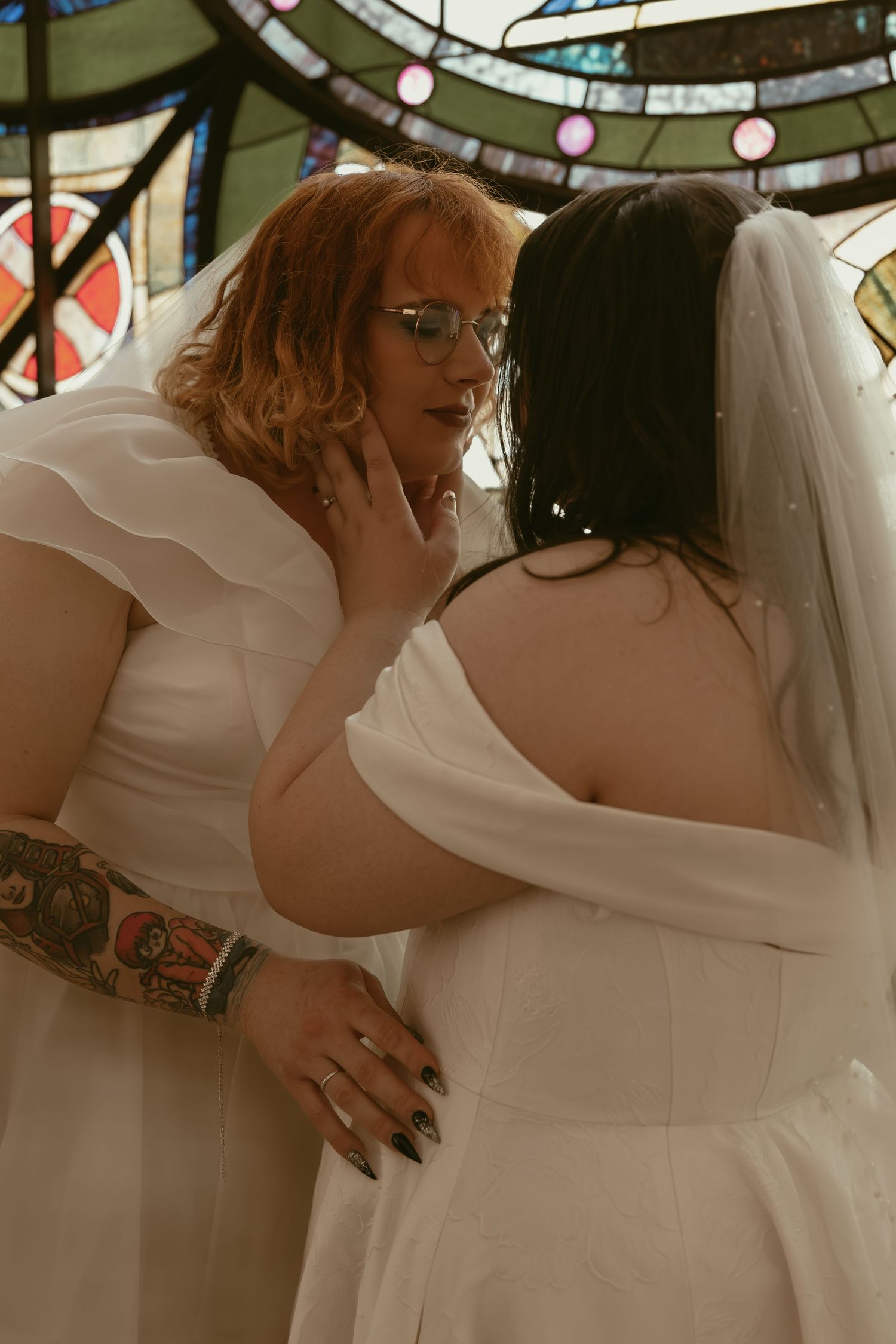 Couple kissing by a stain glass window in Cleveland Ohio by Gypsy Lens Photography. Moody, filmy, vintage, documentary wedding photography.