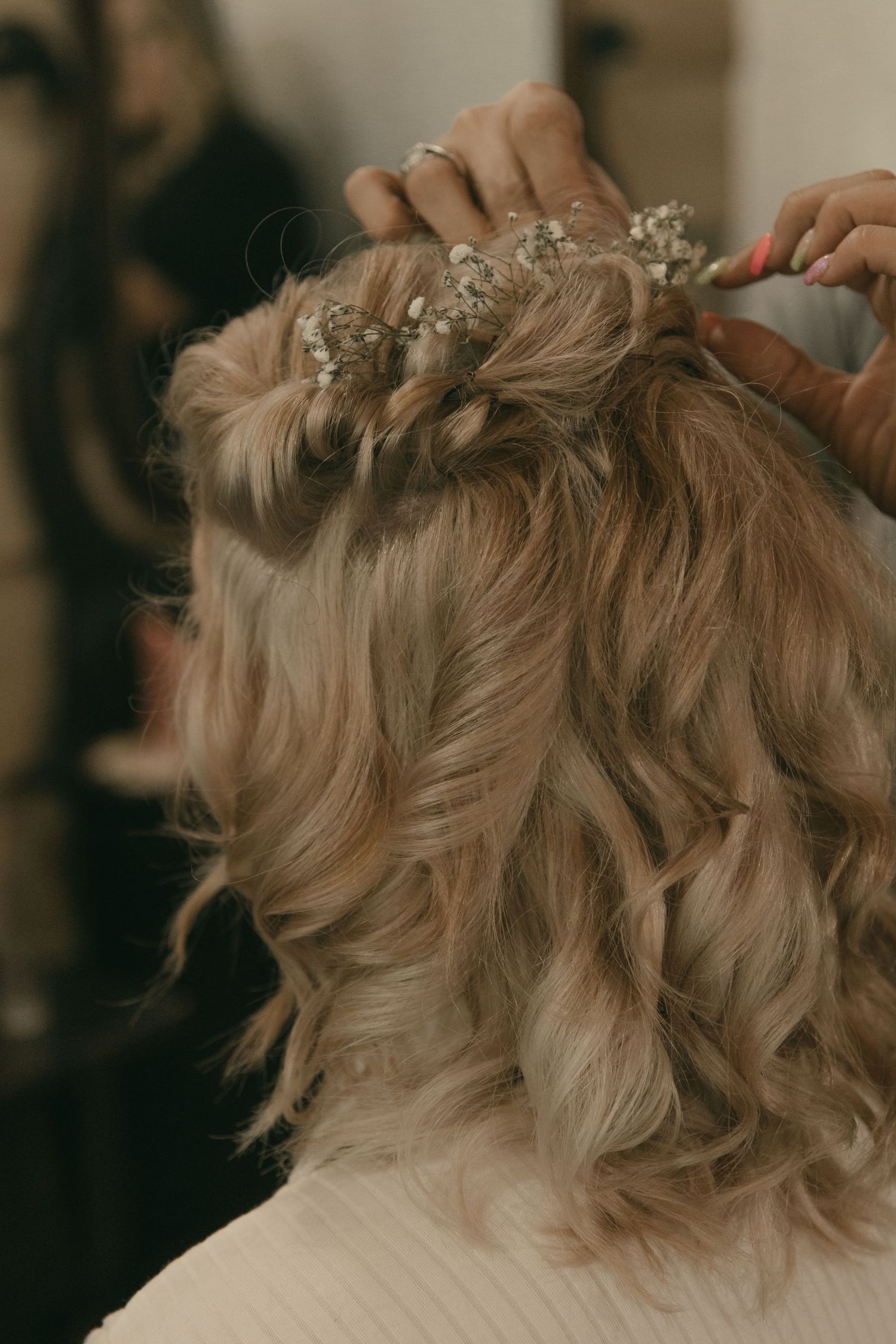 Close-up shots of a bride's hair being styled with delicate curls and flowers in Wooster Ohio by Gypsy Lens Photography. Moody wedding.