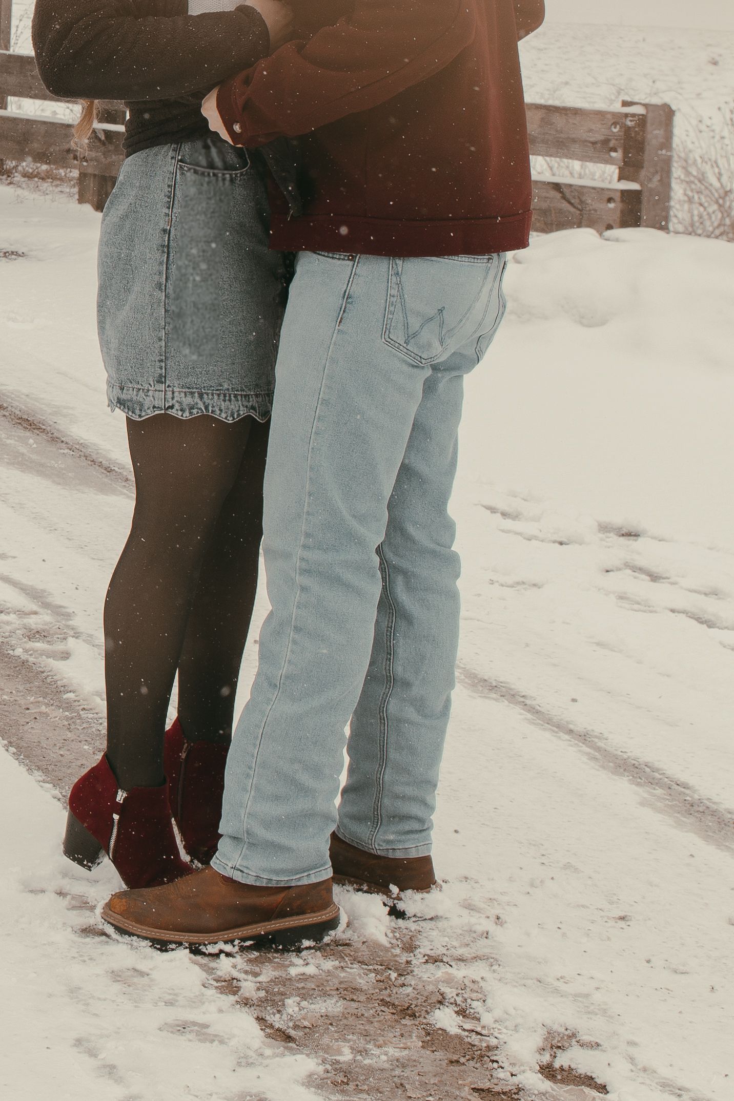 Couple in winter boots standing close together on snowy ground  in Ashtabula Ohio by Gypsy Lens Photography. Moody, vintage, documentary.