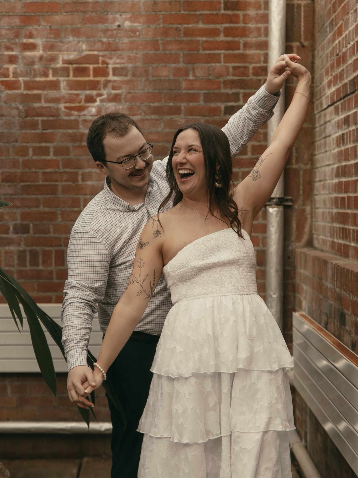Couple laughing candidly at greenhouse Cleveland Ohio by Gypsy Lens Photography. Moody, nostalgic, vintage, documentary wedding photography
