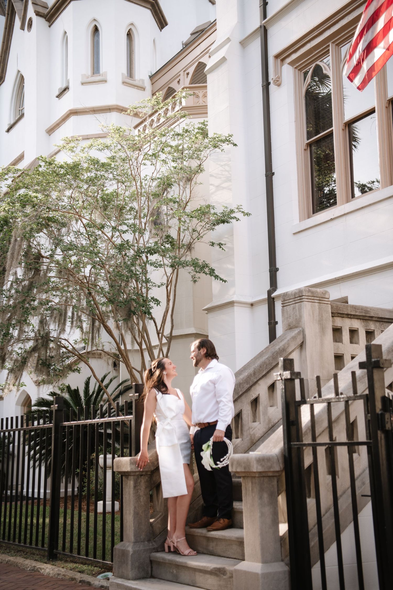 A romantic sequence of photos showing a couple sharing an intimate moment on the steps of a white building with black railings.