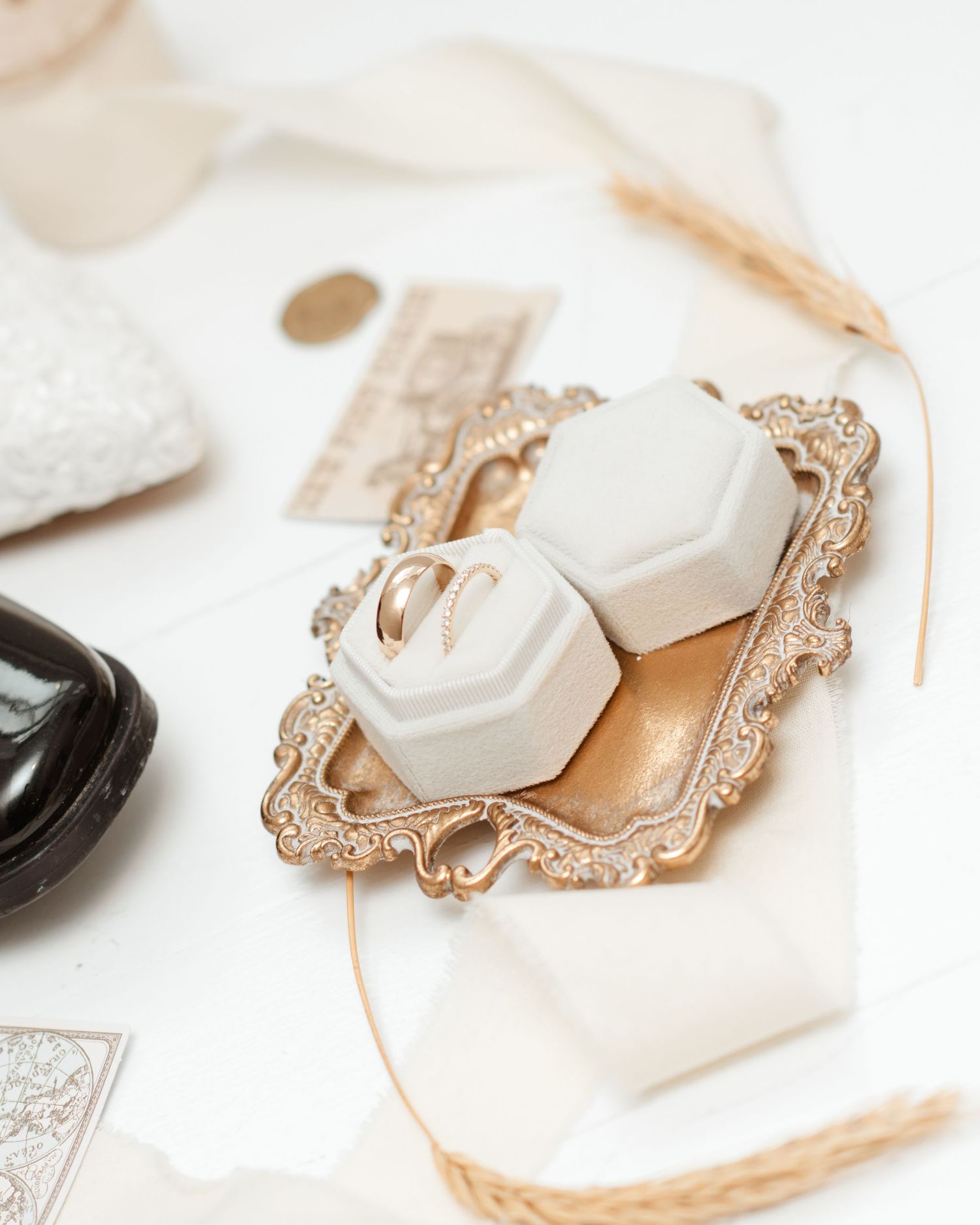 Wedding rings displayed on an ornate gold vintage tray with decorative details.