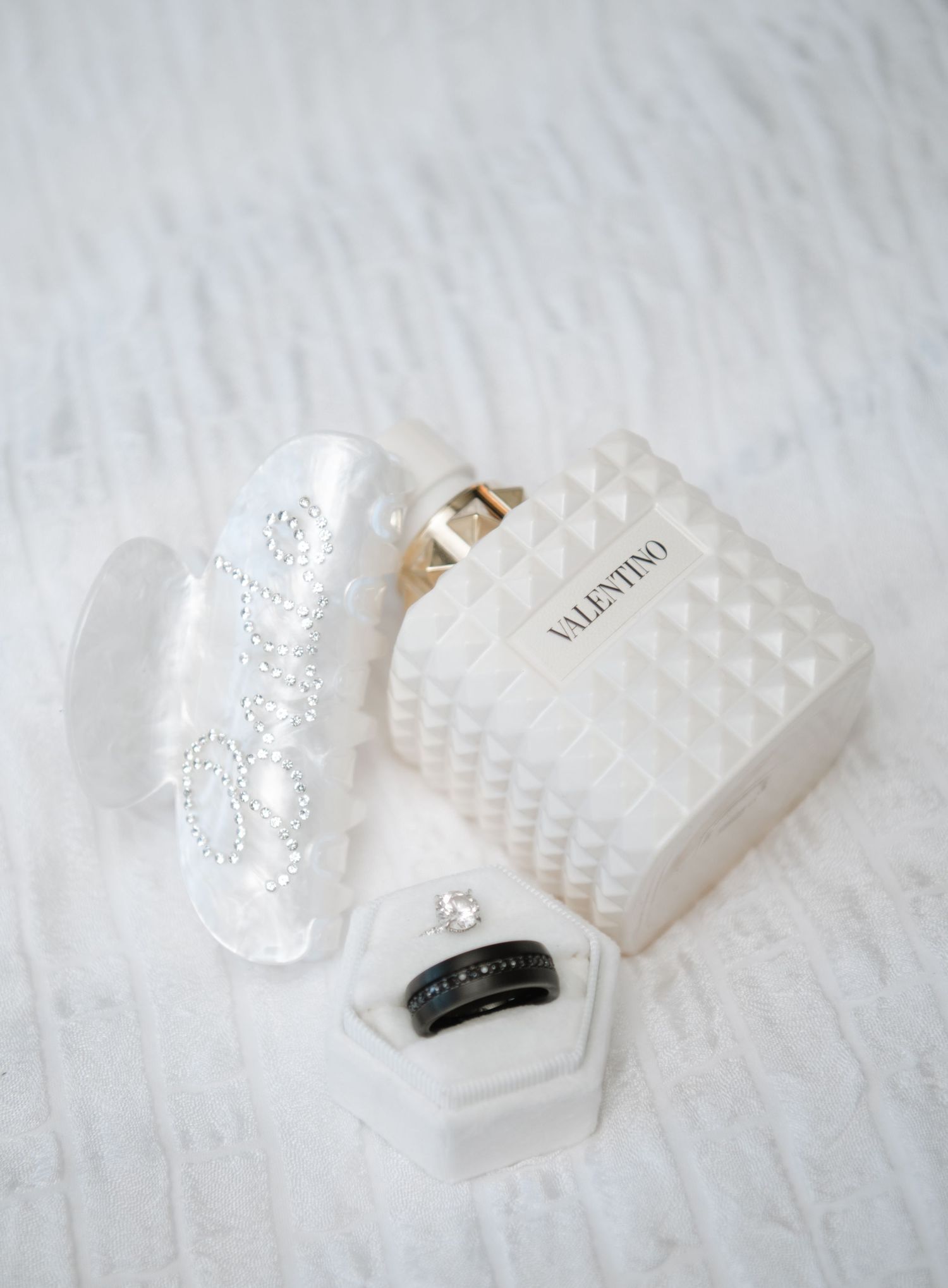 White textured wedding accessories and decorative elements arranged on light background.