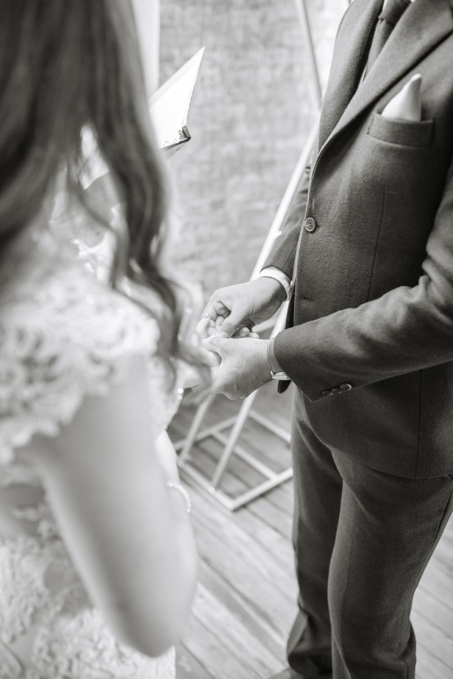 Black and white detail shot of formal attire during wedding ceremony.