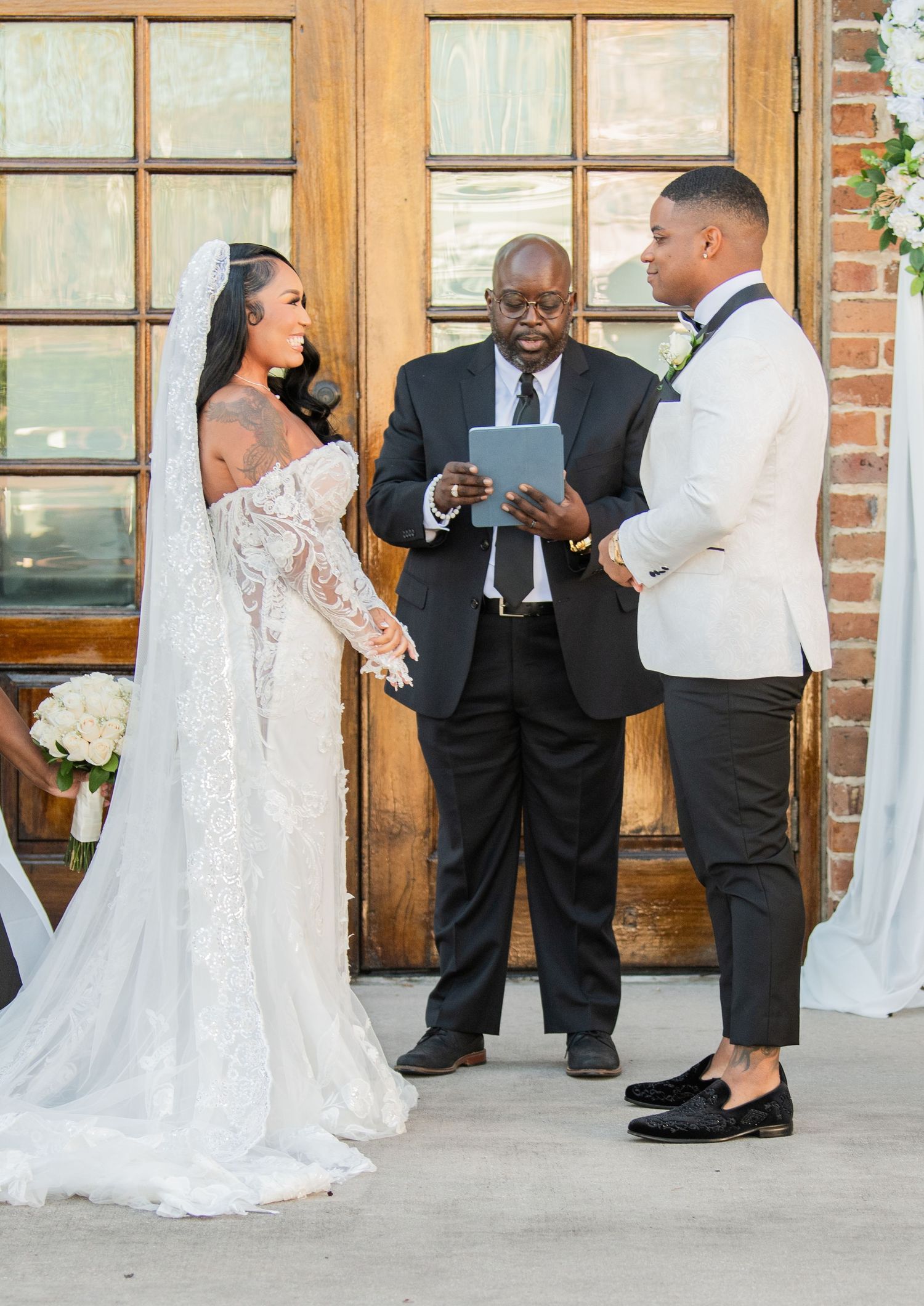 Wedding celebration candid moments captured against brick wall backdrop with elegant decor.