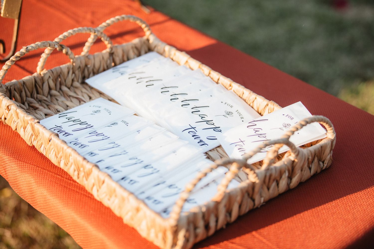 Wedding signage displayed on rustic textured surface with coral-colored accents.