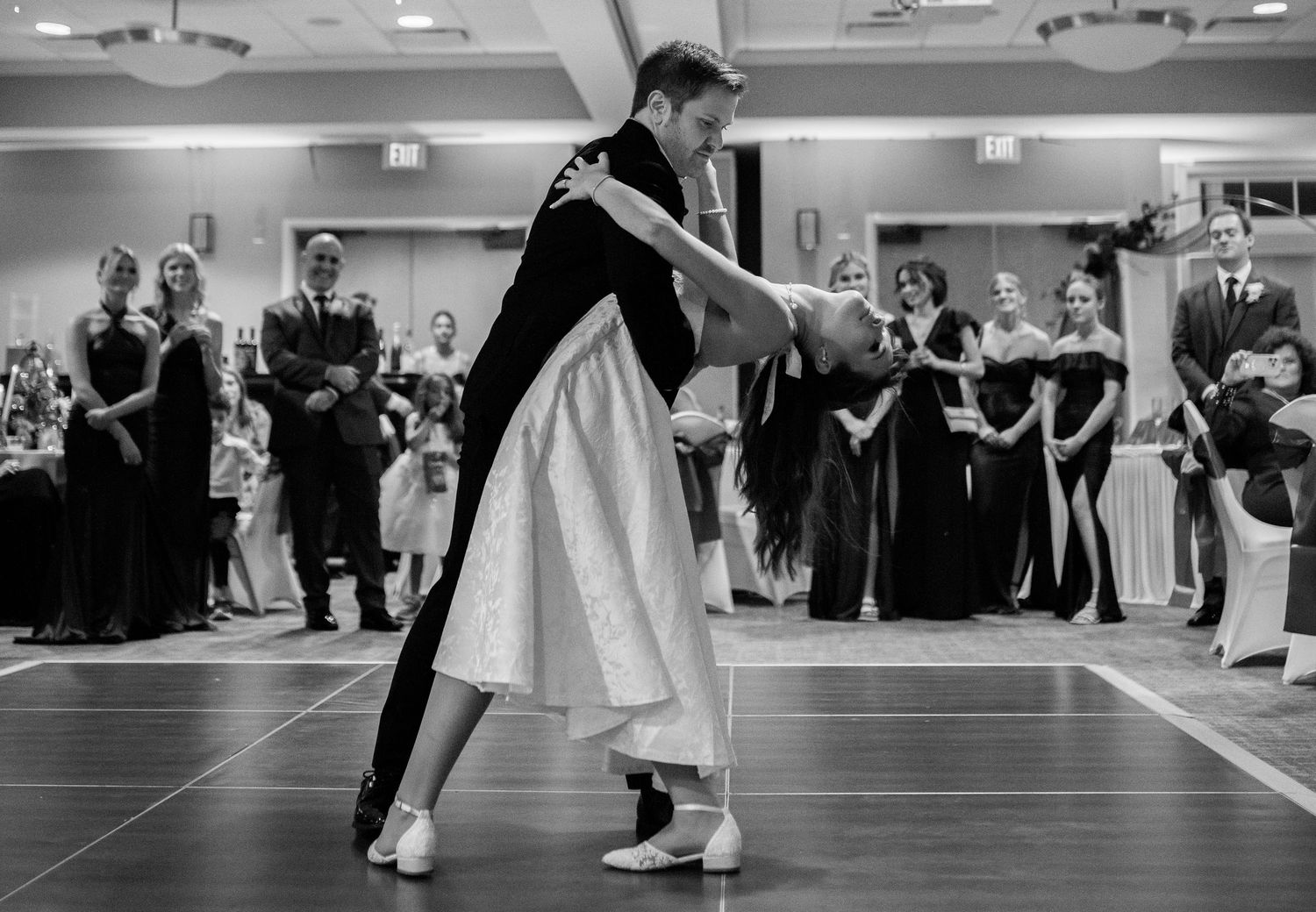 Couples dancing together at a wedding reception on a polished dance floor.