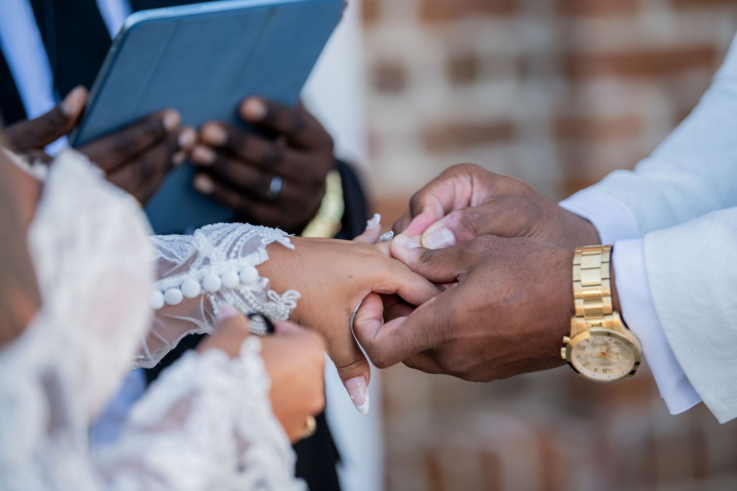 Close-up shots of hands exchanging wedding rings during an elegant ceremony.