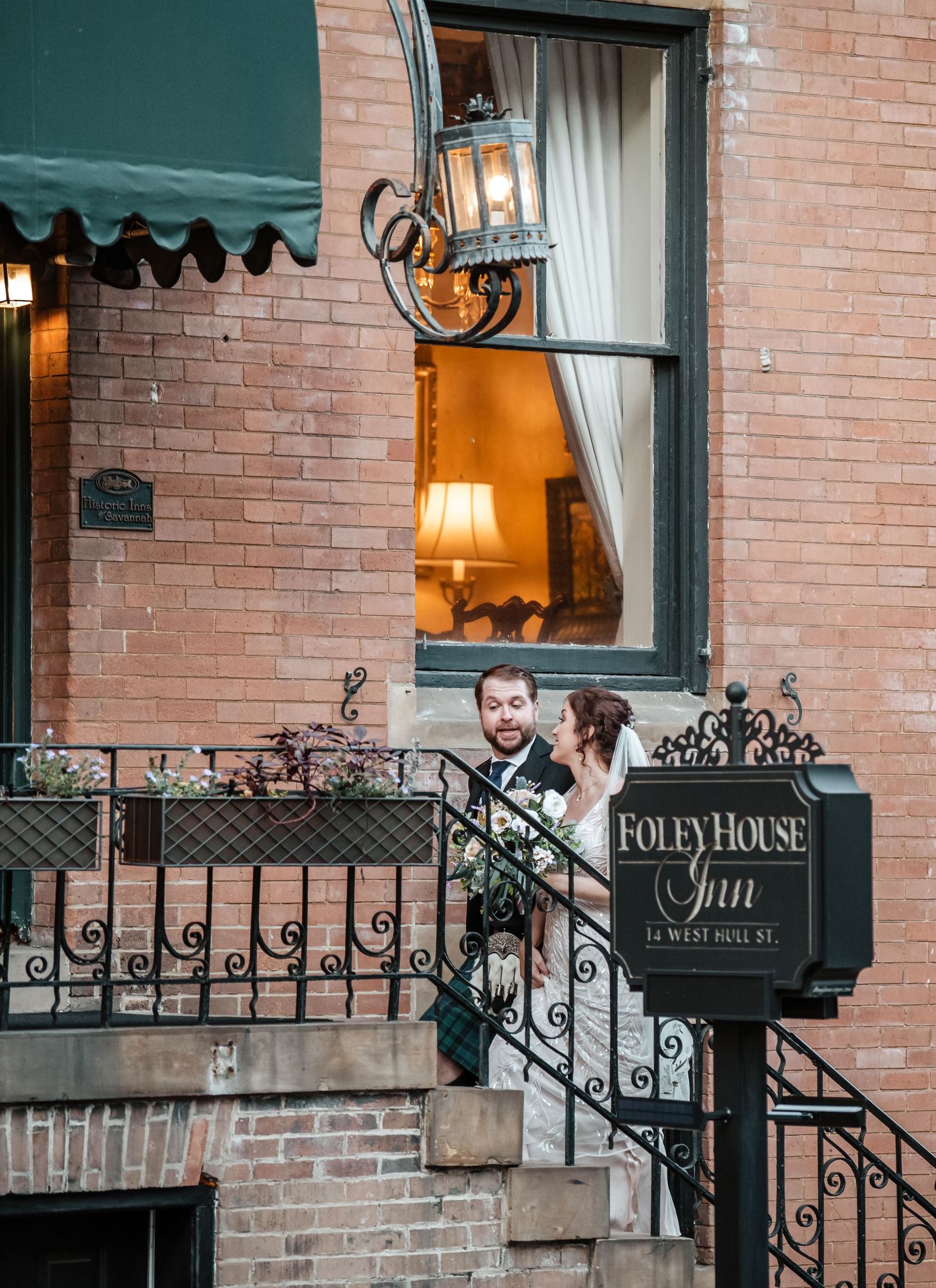 Exterior view of the Foley House Inn with brick facade and ornate iron railings.