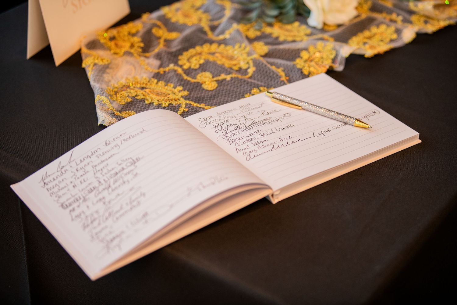 Wedding guest book with handwritten messages and gold decor elements.