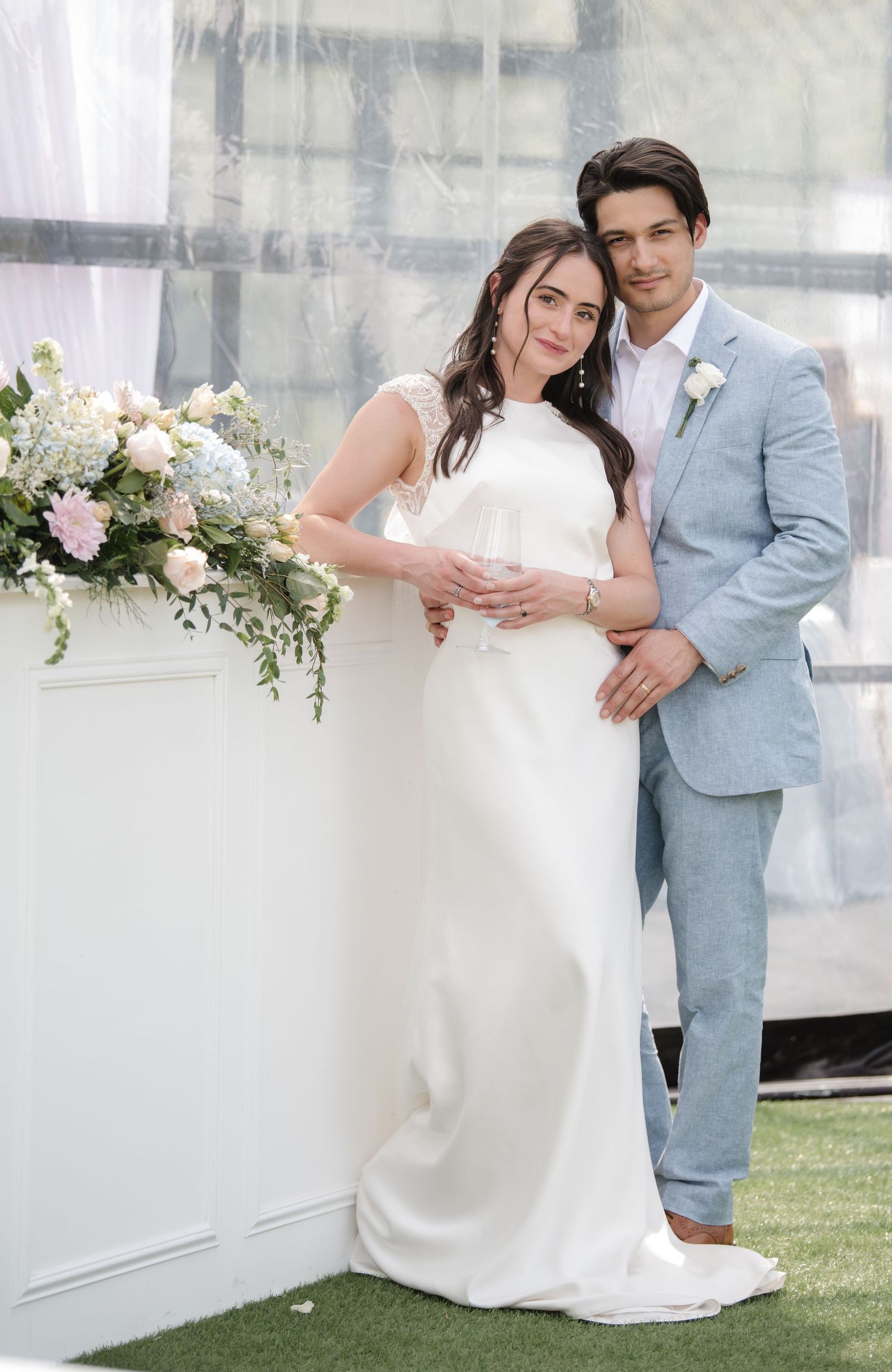 A romantic wedding photo series showing a couple in light blue suit and white gown posing against a bright modern backdrop.