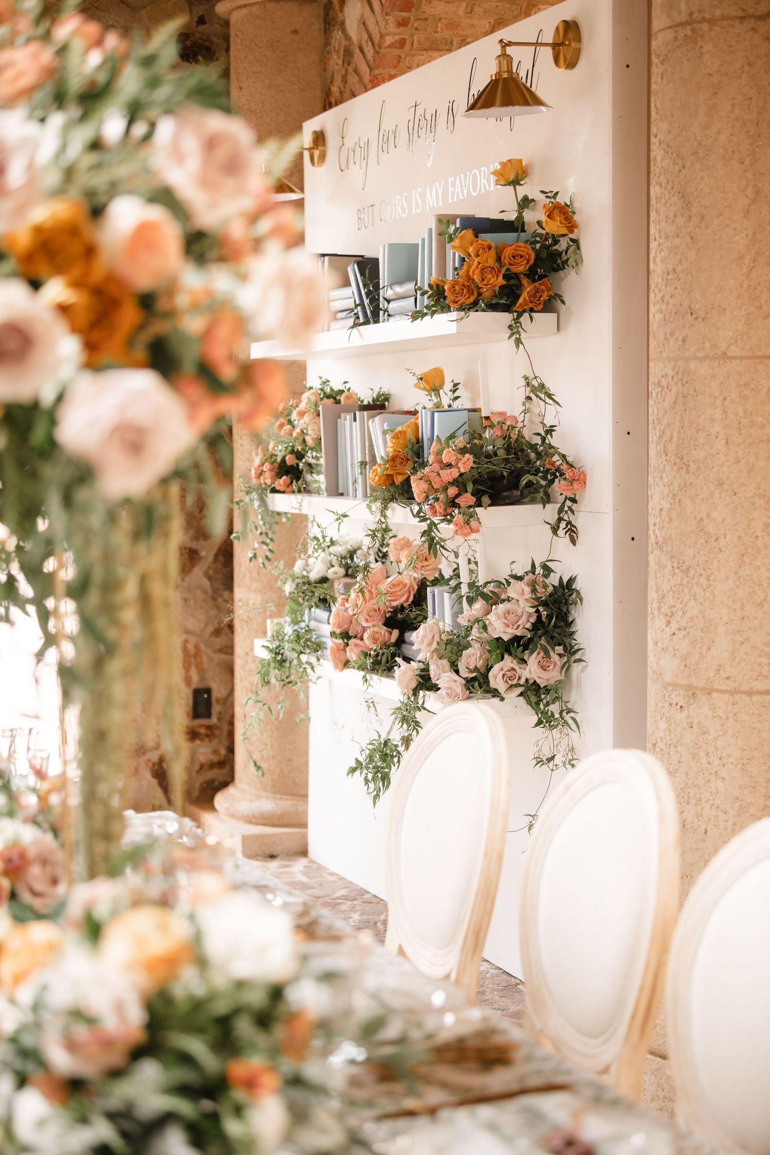 Romantic peach floral arrangements decorate a stone column reception space.