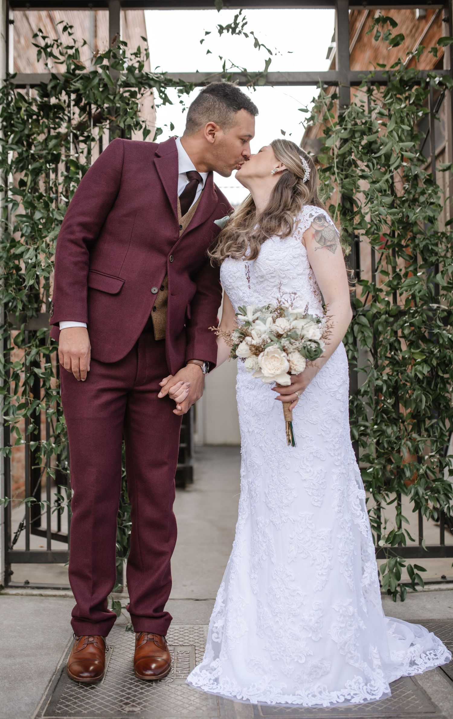 Wedding couple shares intimate moments in venue decorated with climbing vines and natural light.