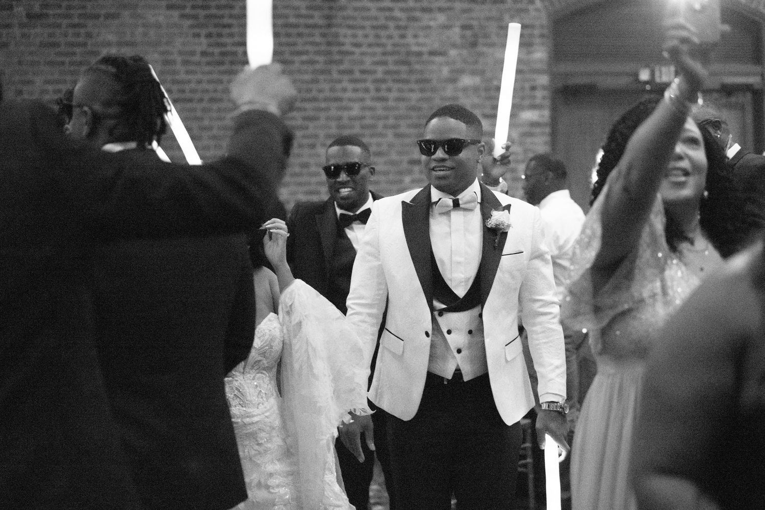 Wedding celebration with guests dancing energetically in formal attire.