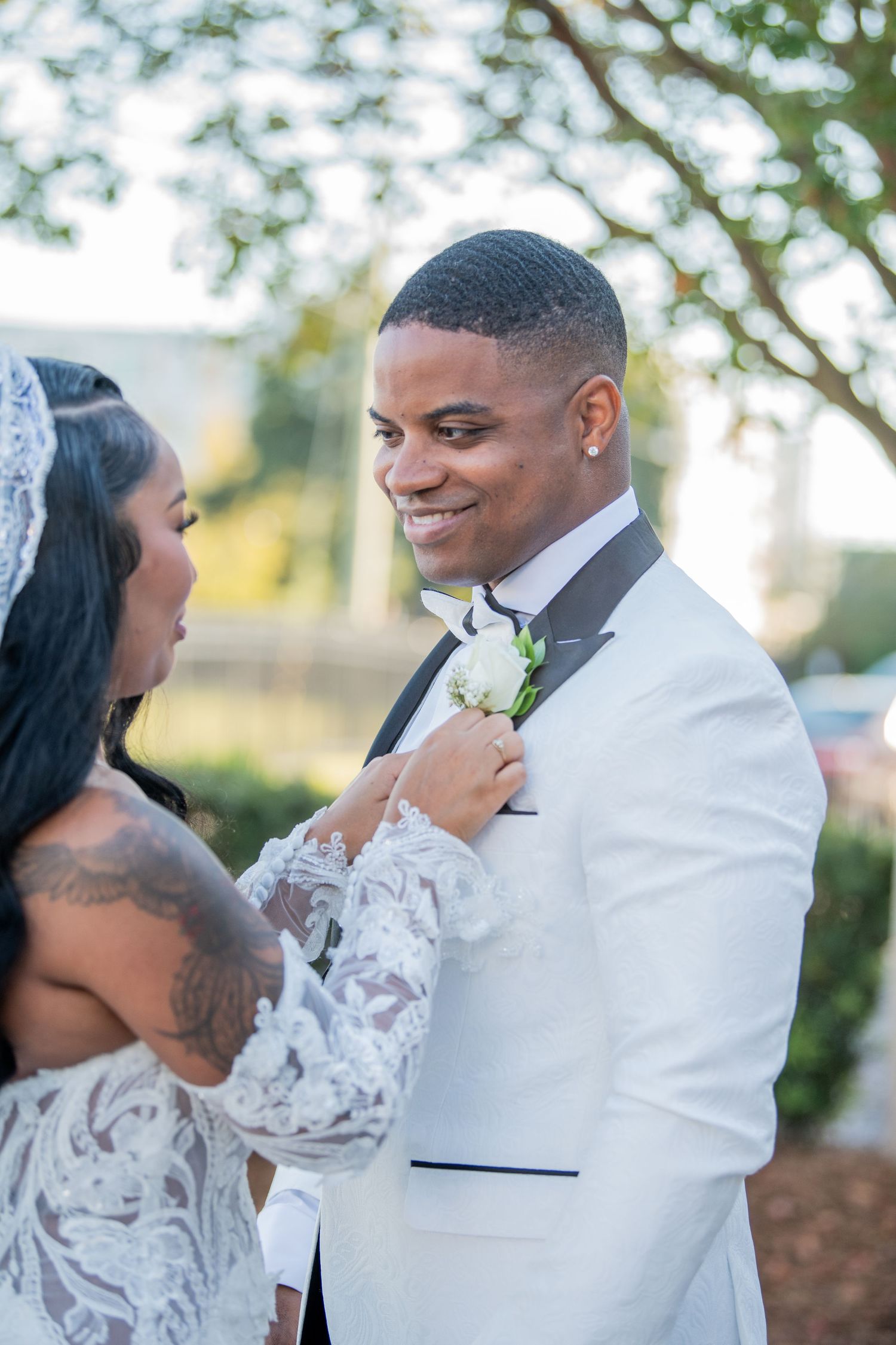 Joyful outdoor wedding portraits showing natural expressions and white formal attire.